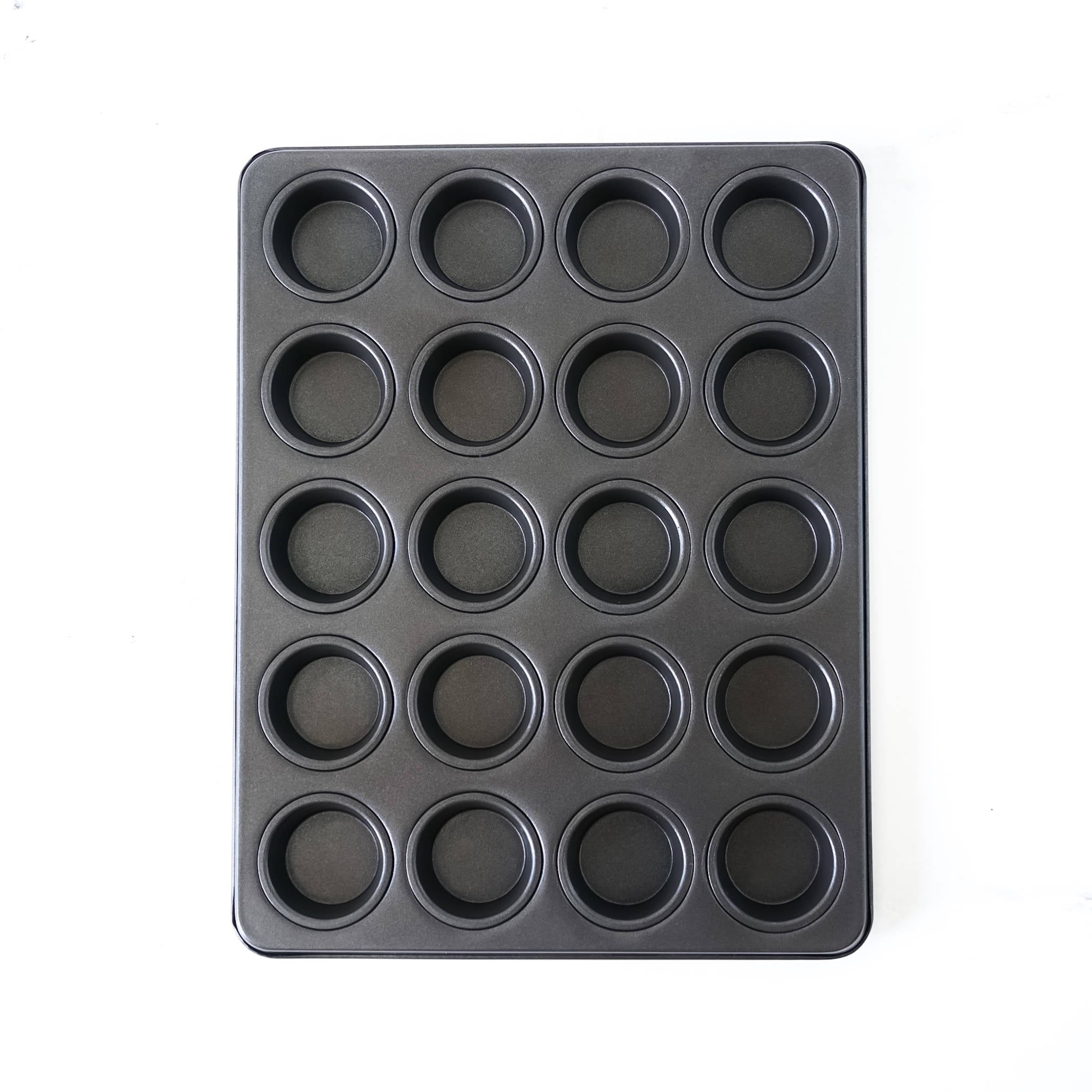 Black cupcake pan with multiple compartments on a white background