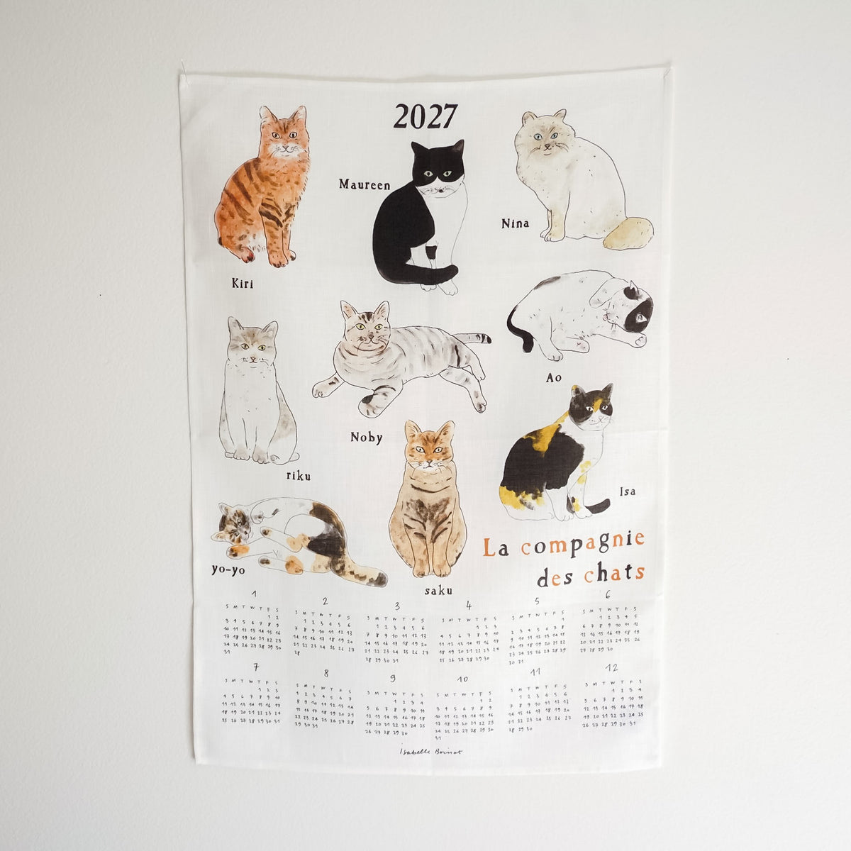 A 2027 French cat calendar poster featuring illustrated cats labeled with their names, including Kiri, Maureen, Nina, Ao, Nobby, Riku, Yo-Yo, Zaku, and Ira. The bottom half shows the printed calendar grids for each month, with the title &