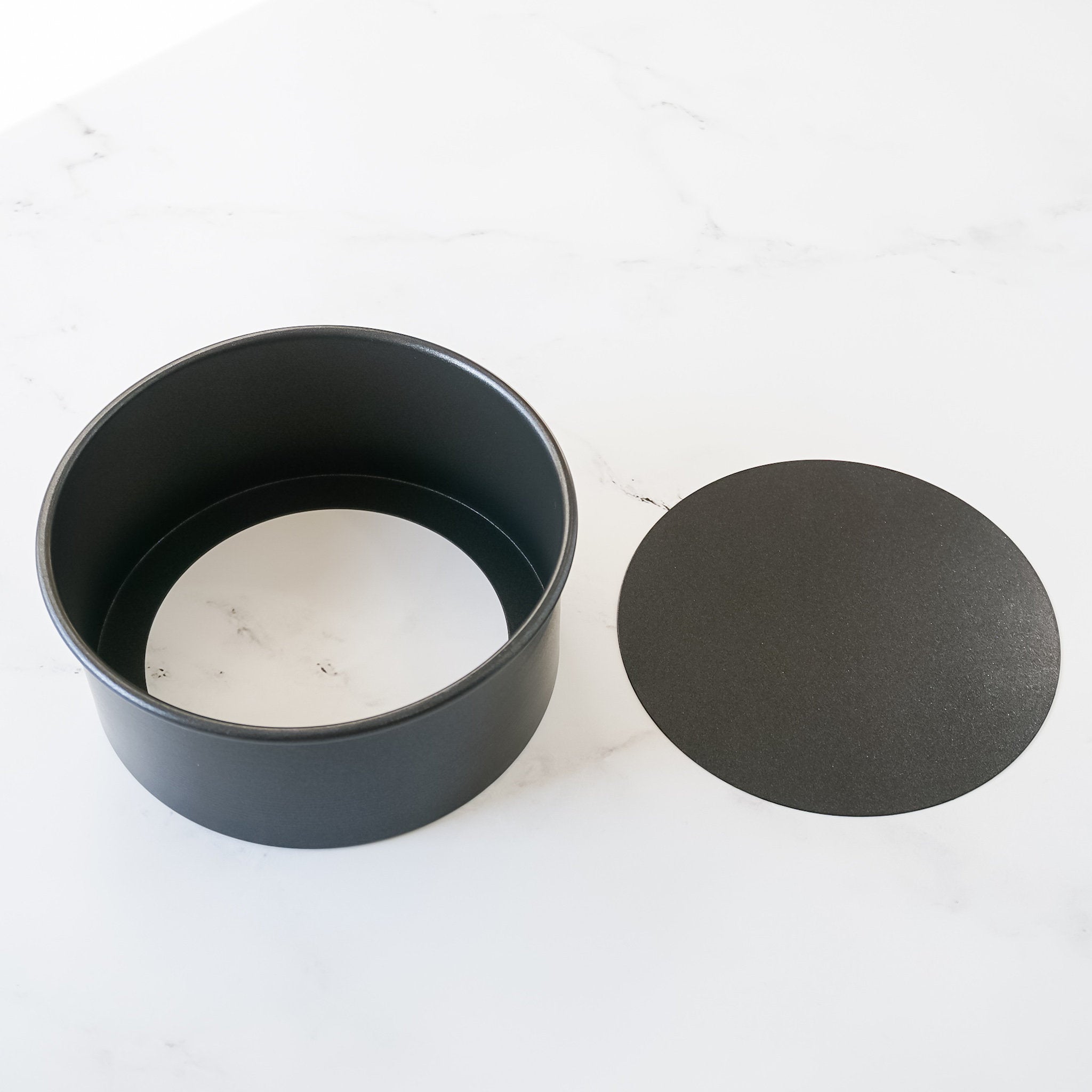 A 6 inch round cake pan with a removable bottom, both displayed on a white background.