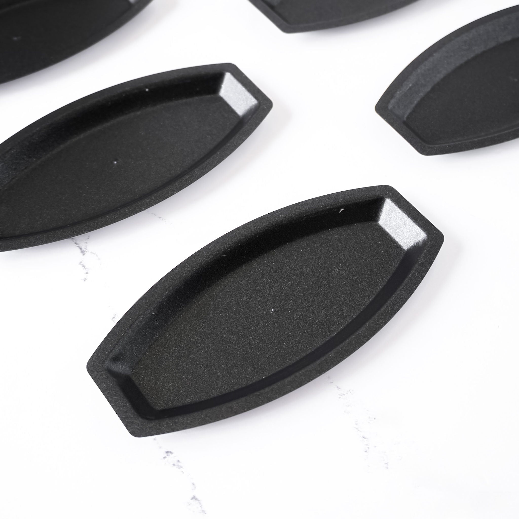 Black salted butter roll molds on a white background