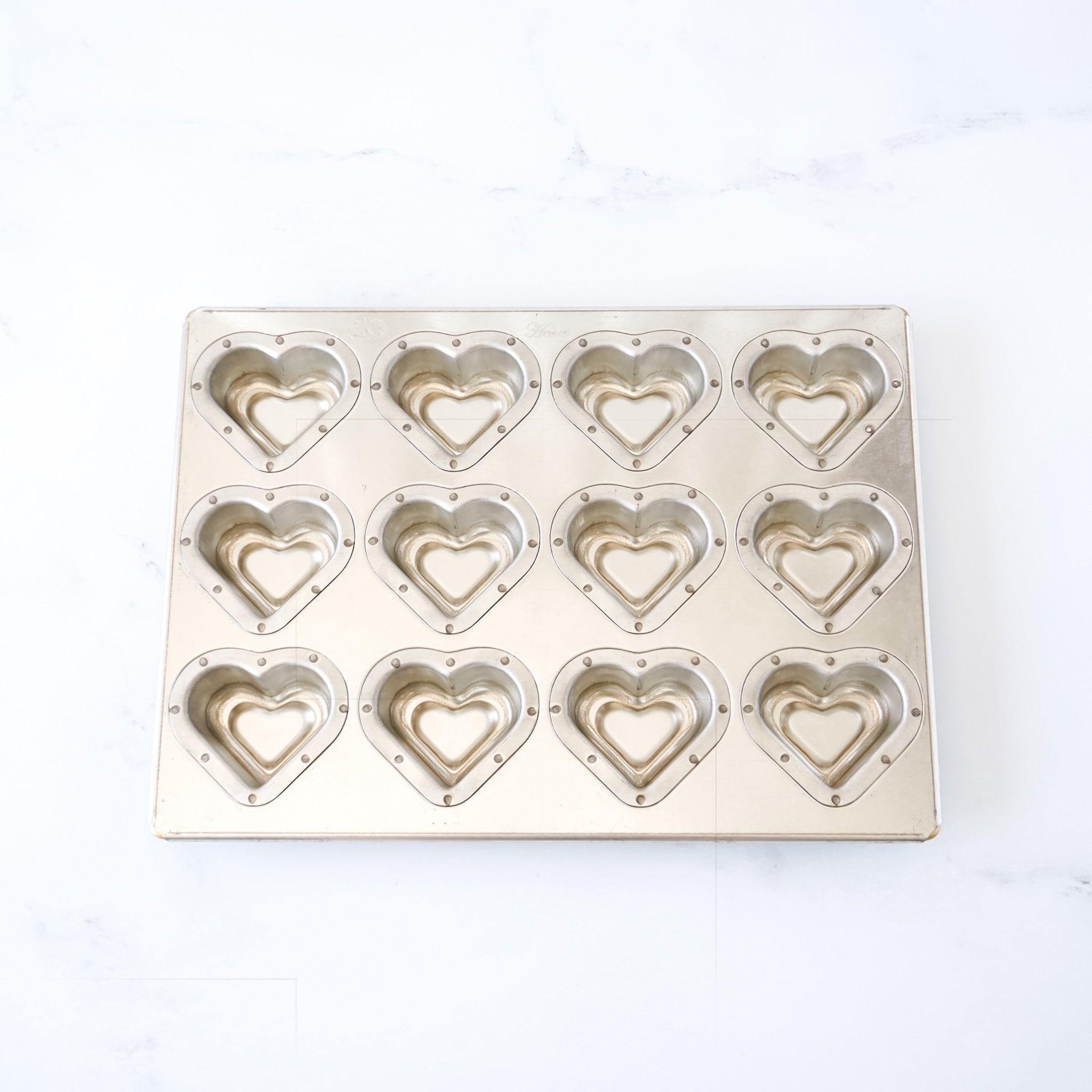 Metallic heart-shaped mold on a white background
