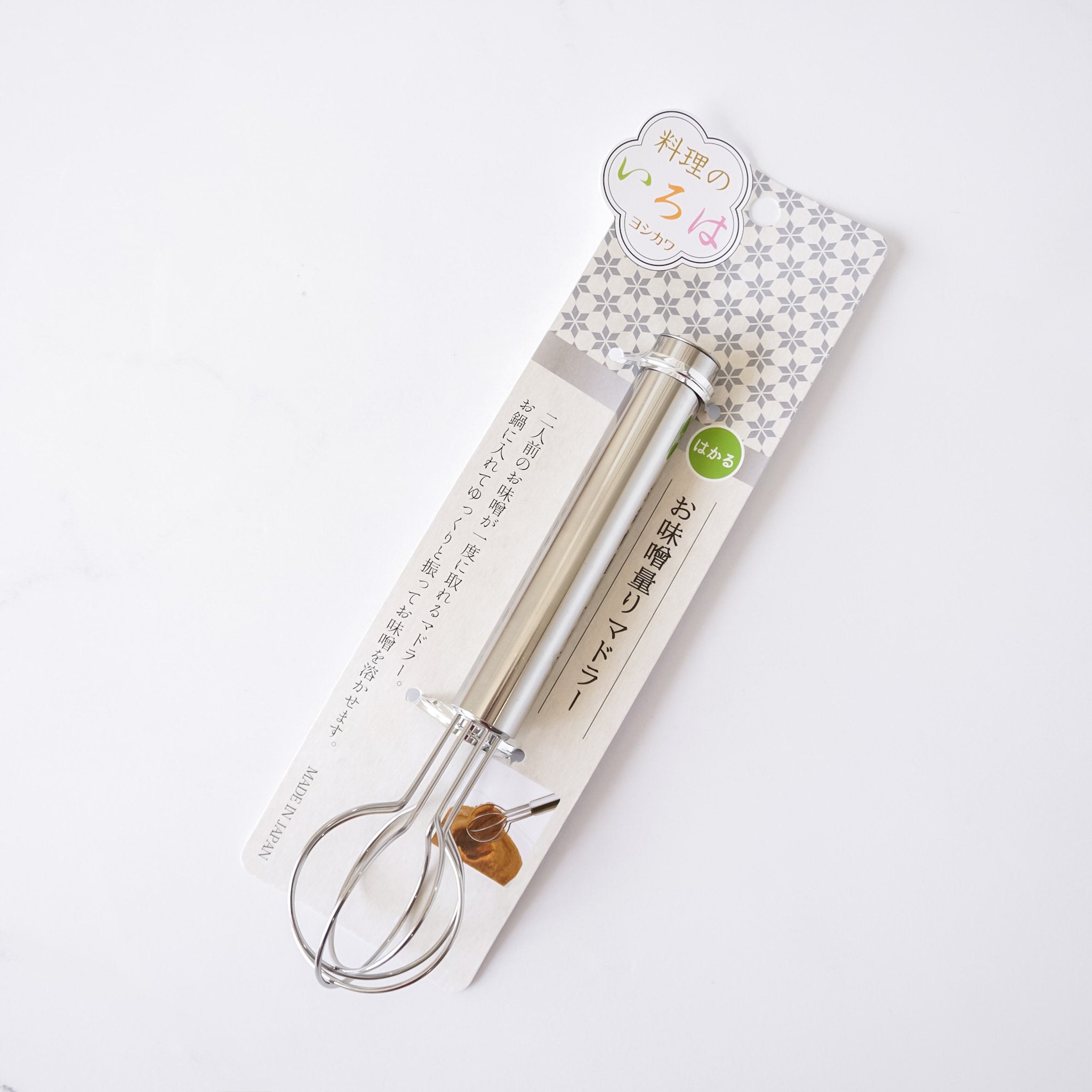 Metal whisk on a branded packaging with Japanese text