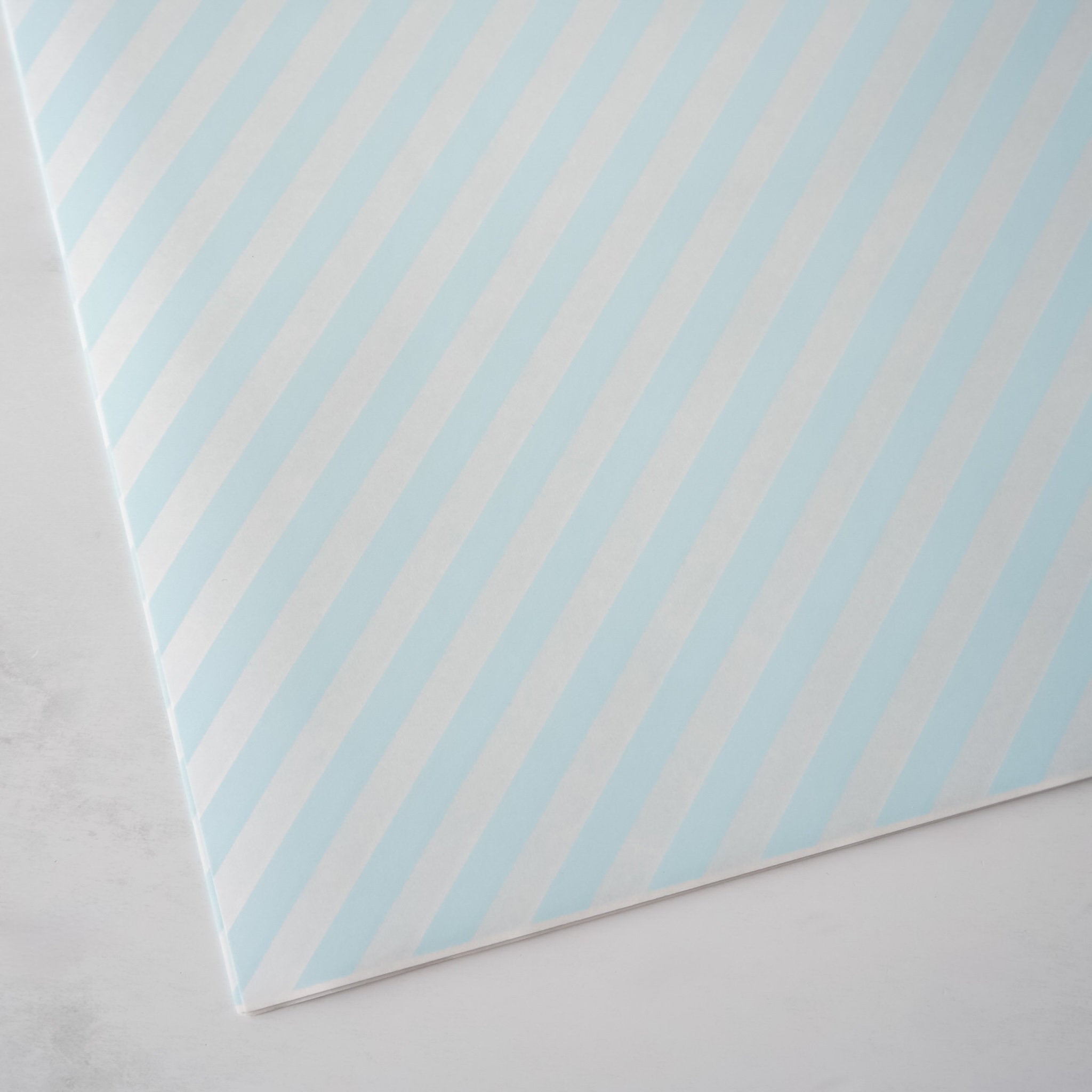 Sheet of paper with blue diagonal stripes on a light gray background