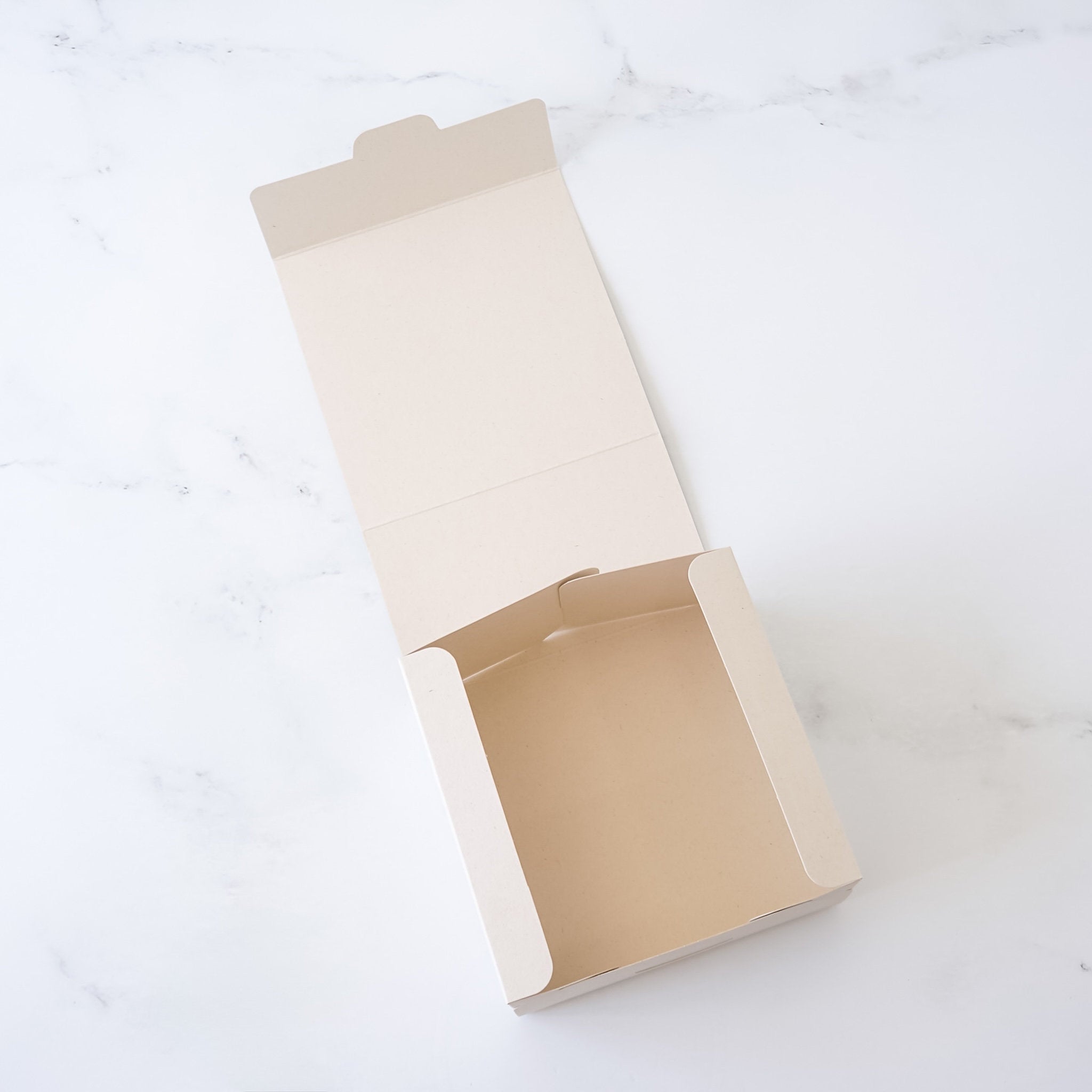 Open beige bakery box on a white background