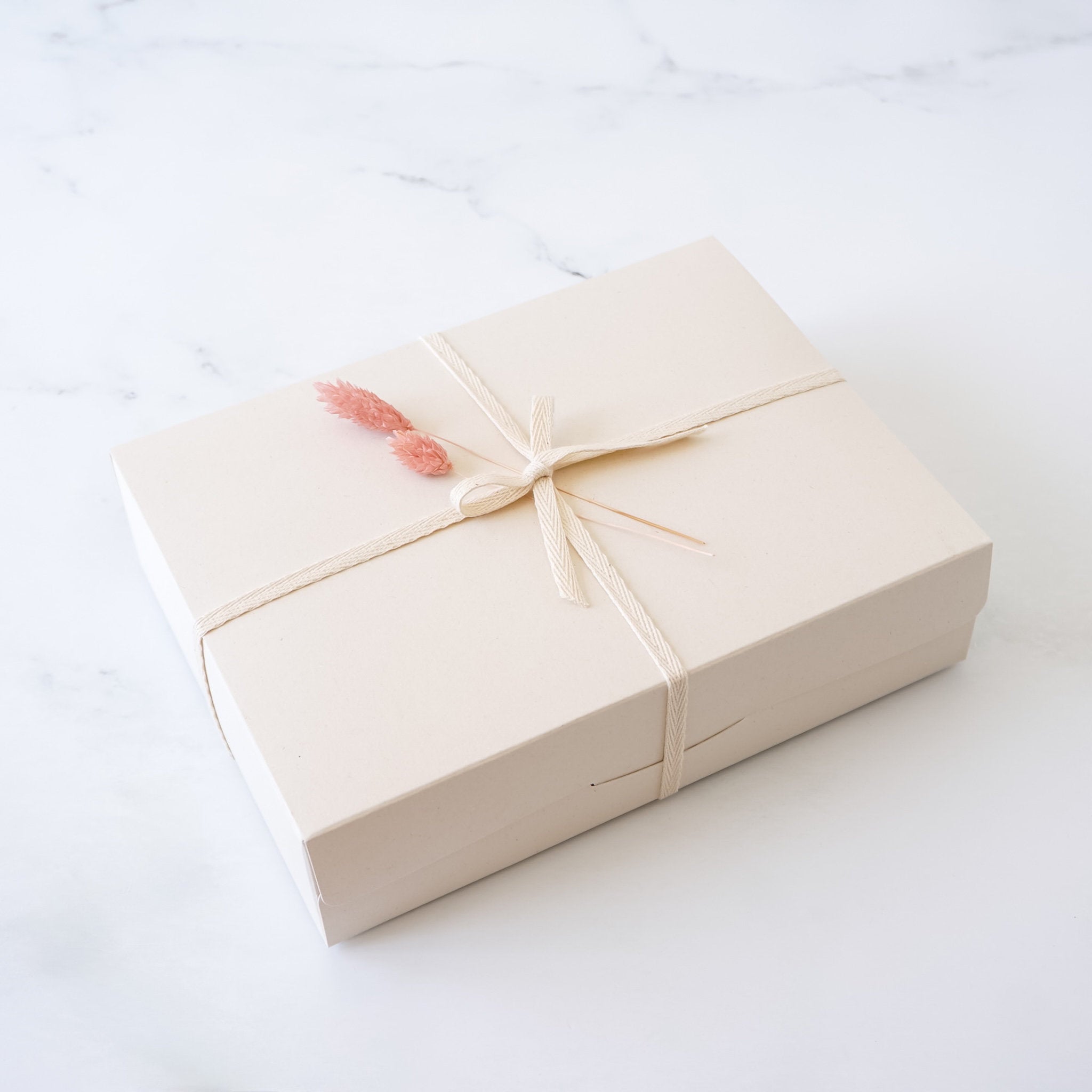 Beige gift box with a pink bow on a white background