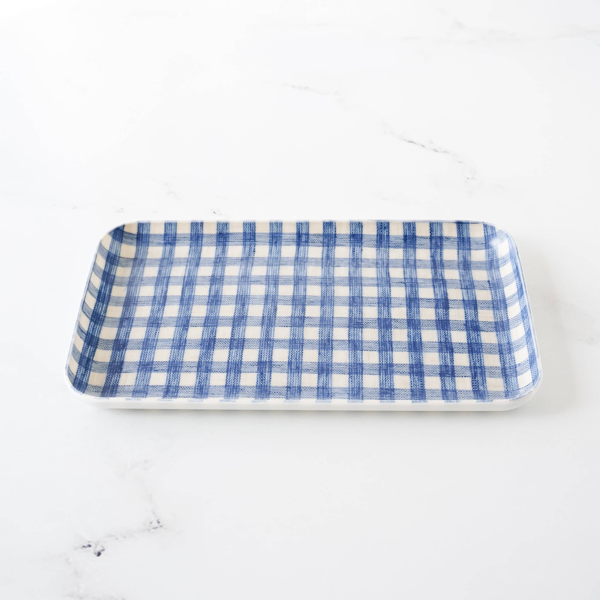 A rectangular blue and white gingham patterned linen coated tray on a white background.