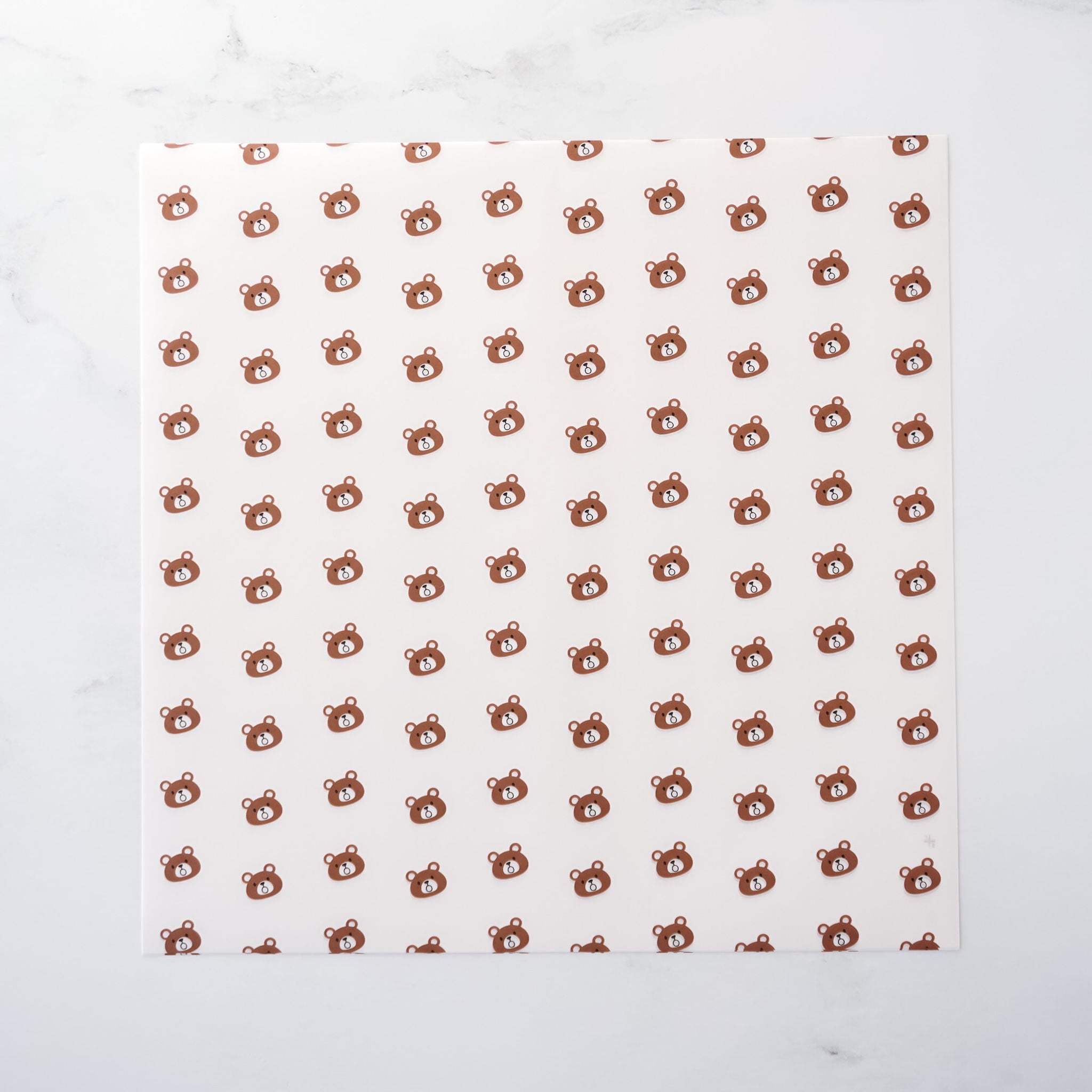 White paper with brown bear pattern on a white background