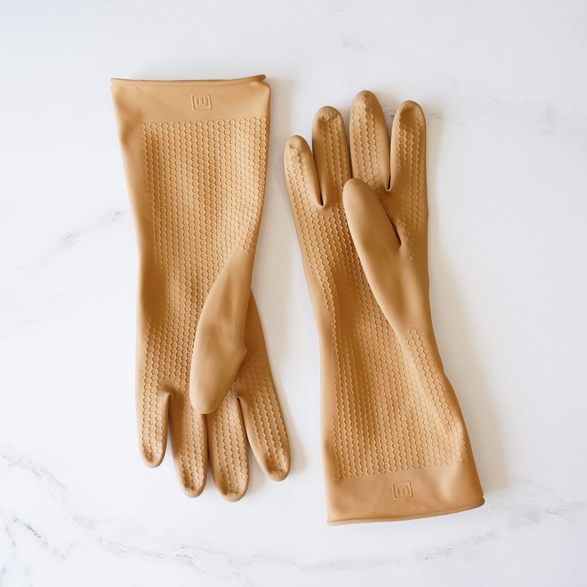 Two pairs of tan rubber dishwashing gloves with a honeycomb texture. The gloves have a logo on the wrist that says &