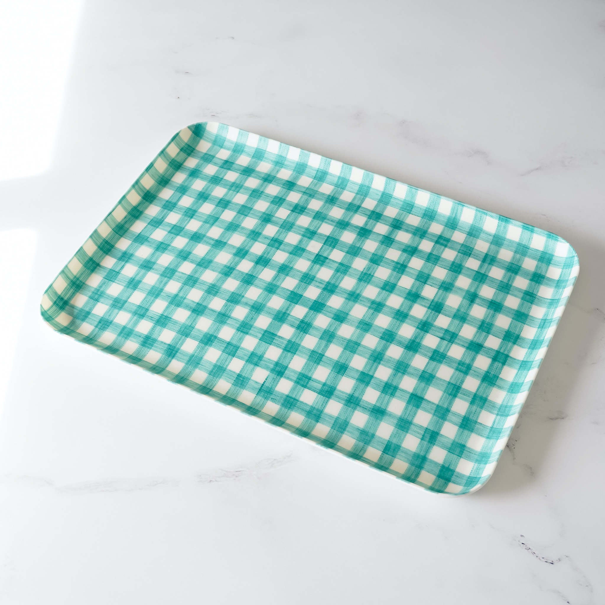 A green check linen coated tray placed on a white surface.