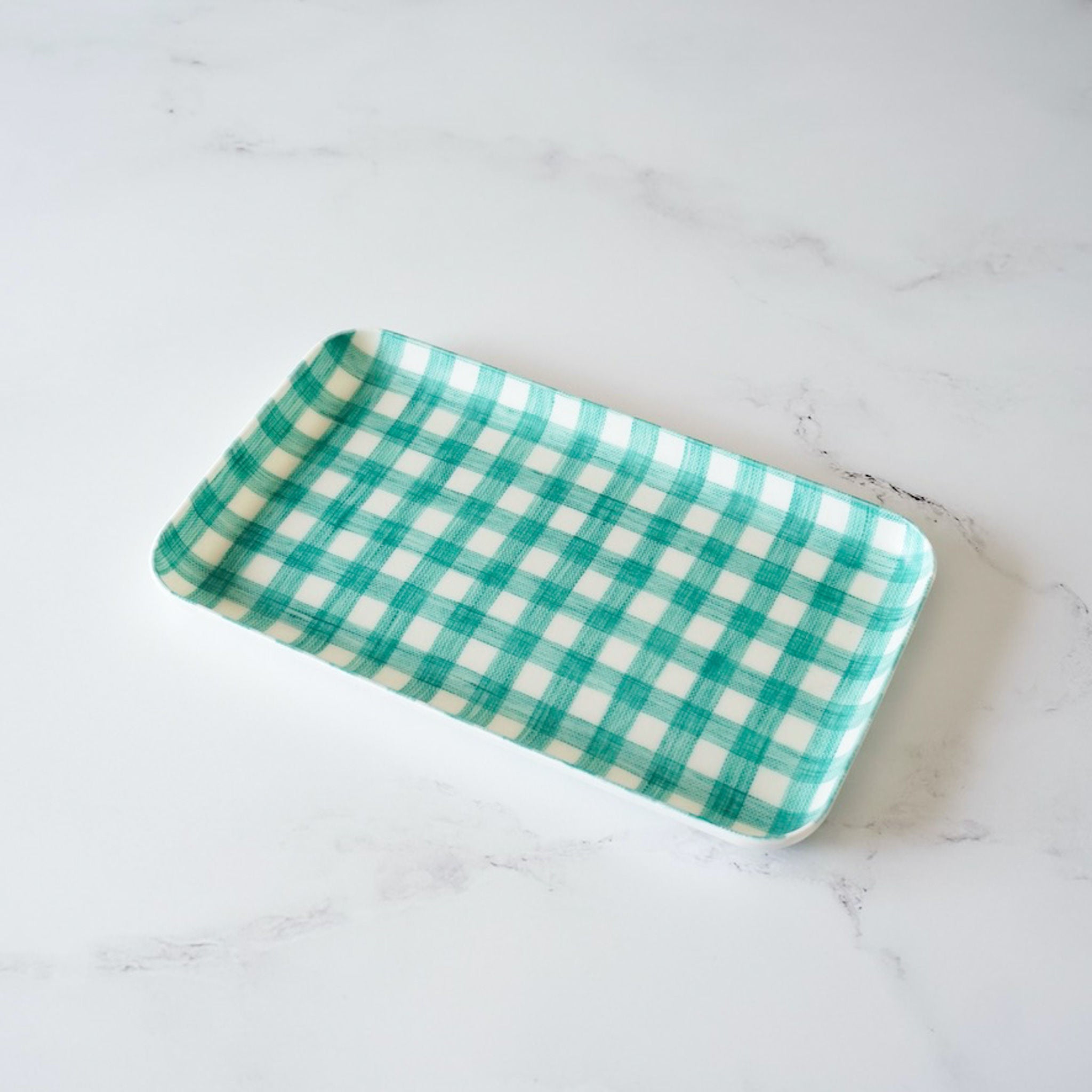 A green check linen coated tray placed on a white surface.