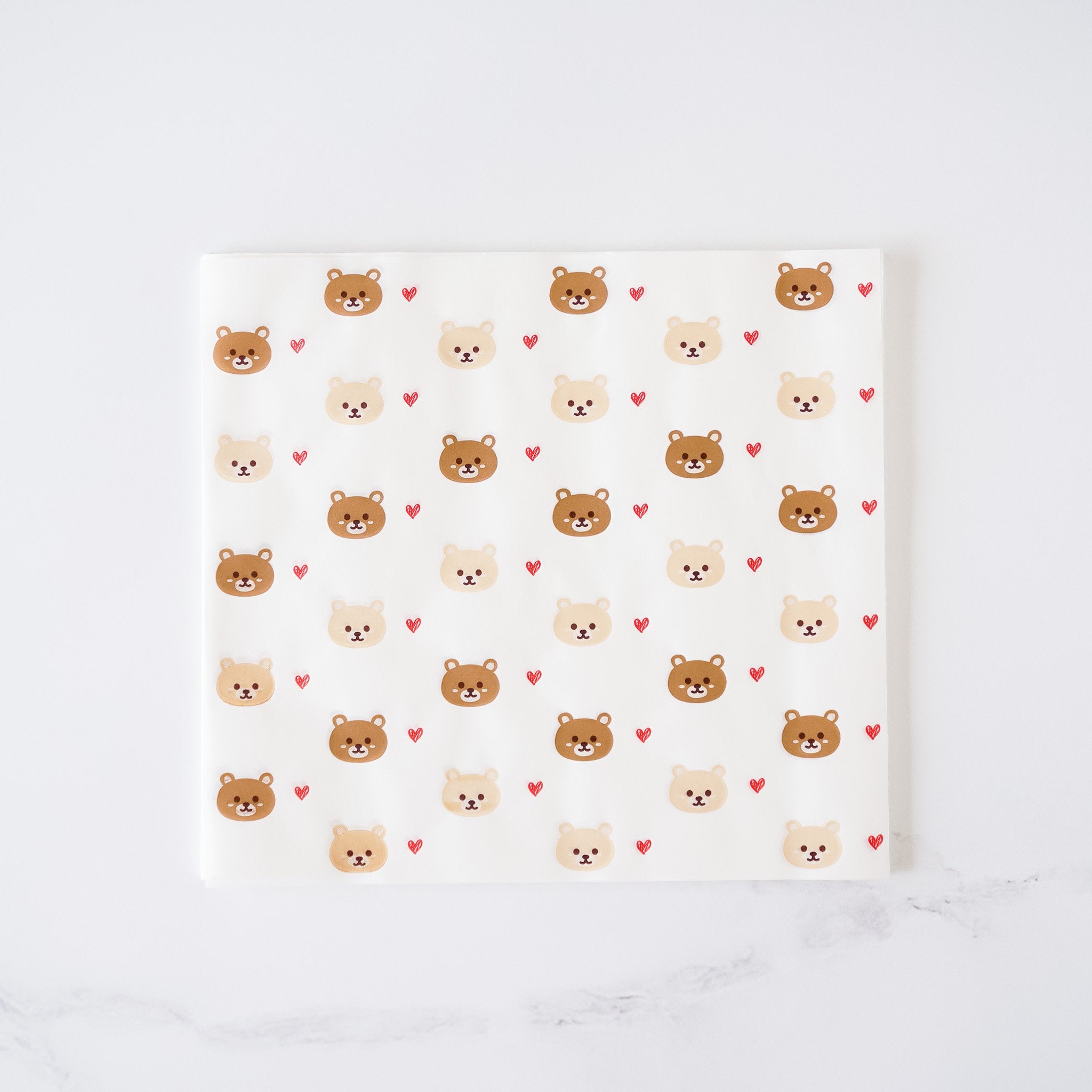 A sheet of deli paper with a bear and heart pattern.