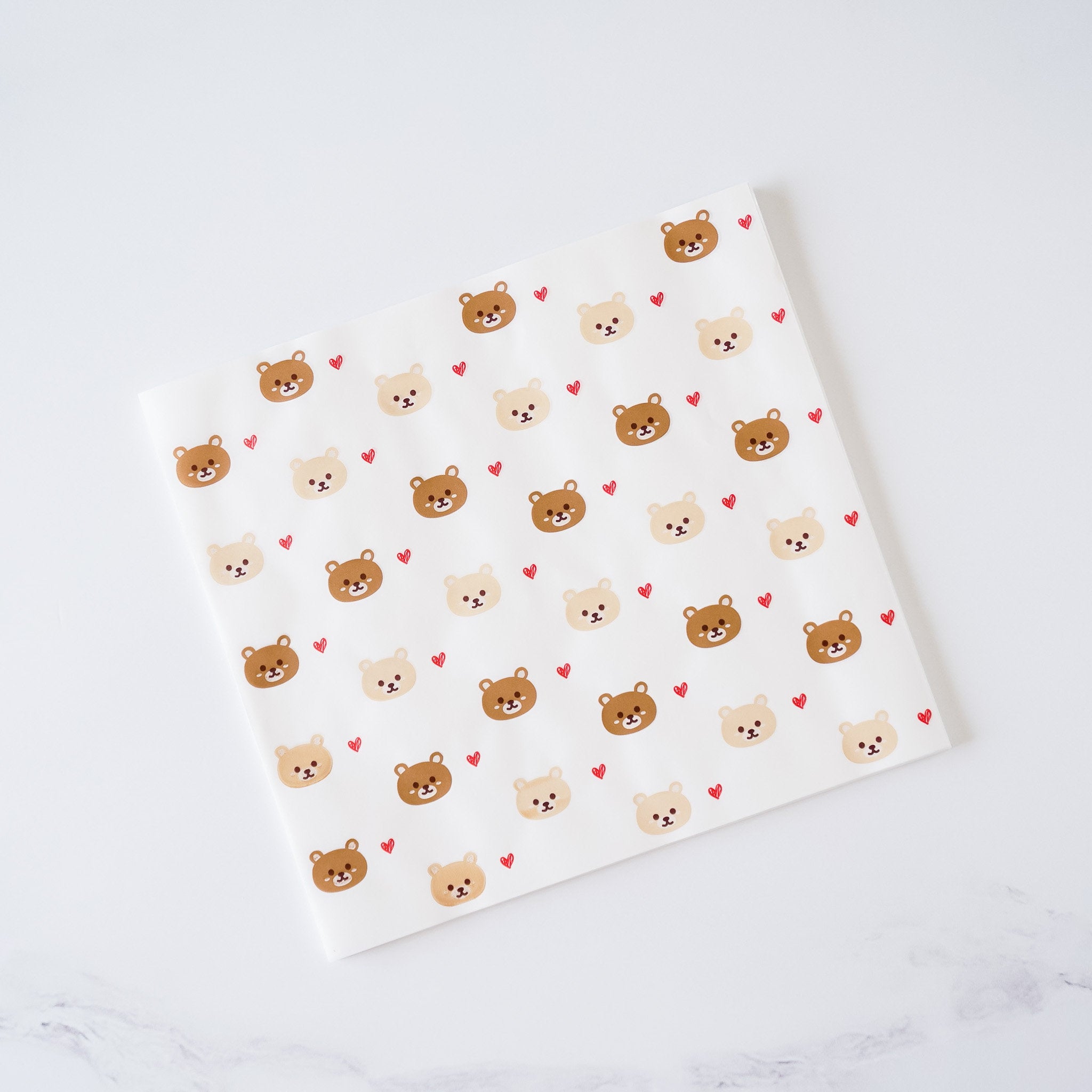 A sheet of mini deli paper with a bear and heart pattern.