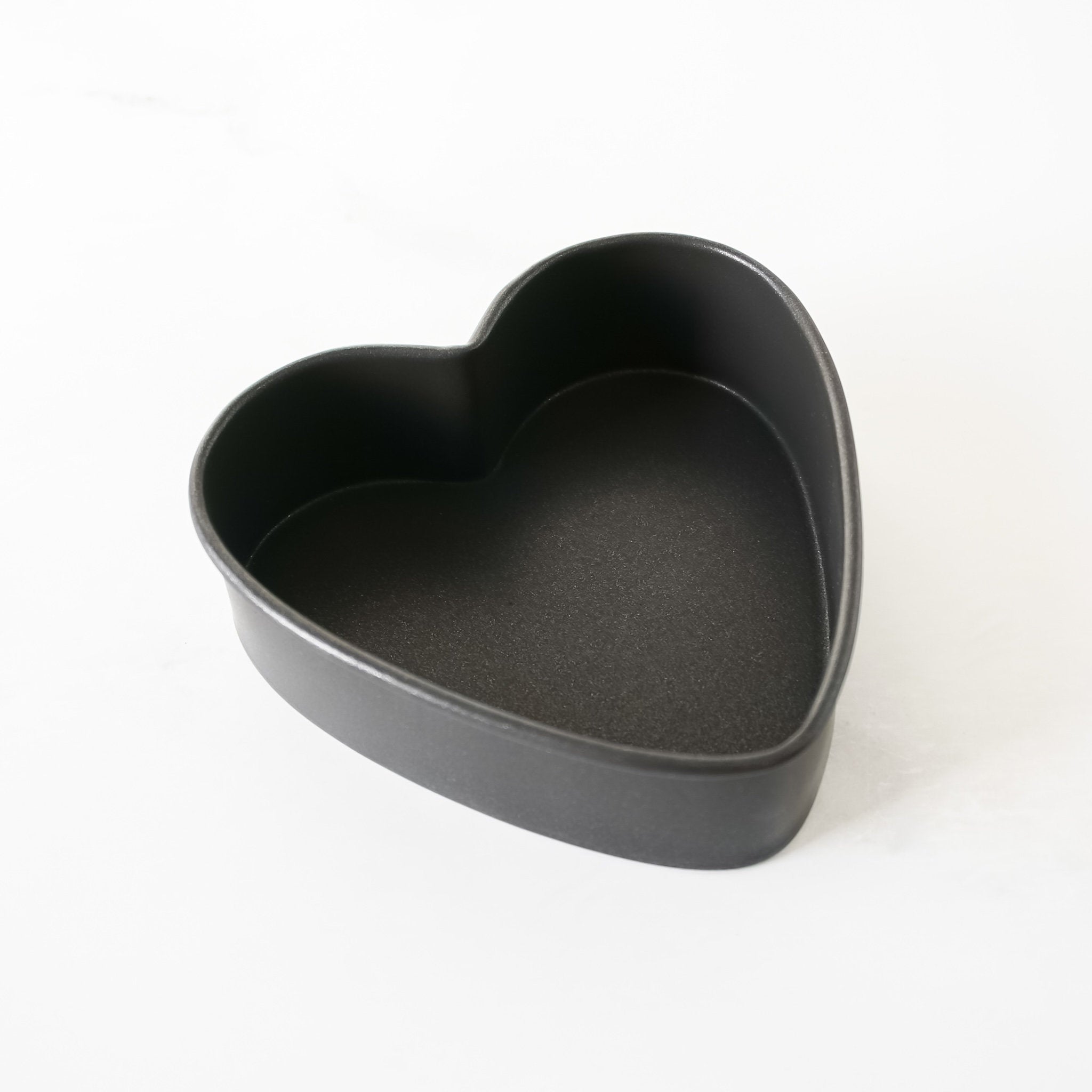 Heart-shaped black baking pan on a white background