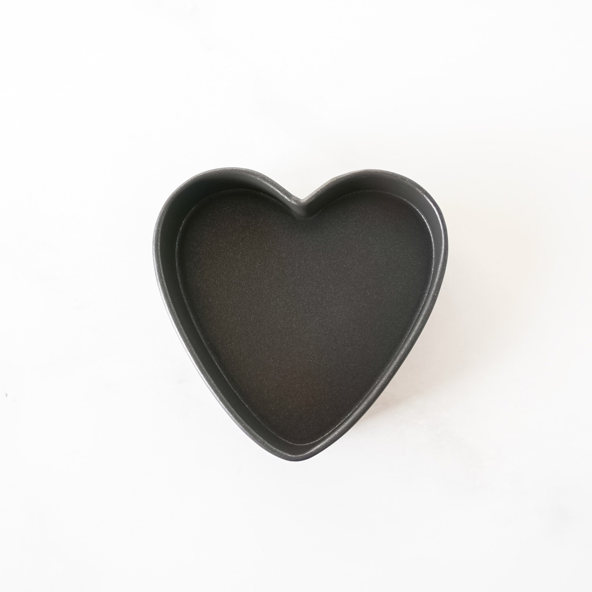 Heart-shaped black baking pan on a white background