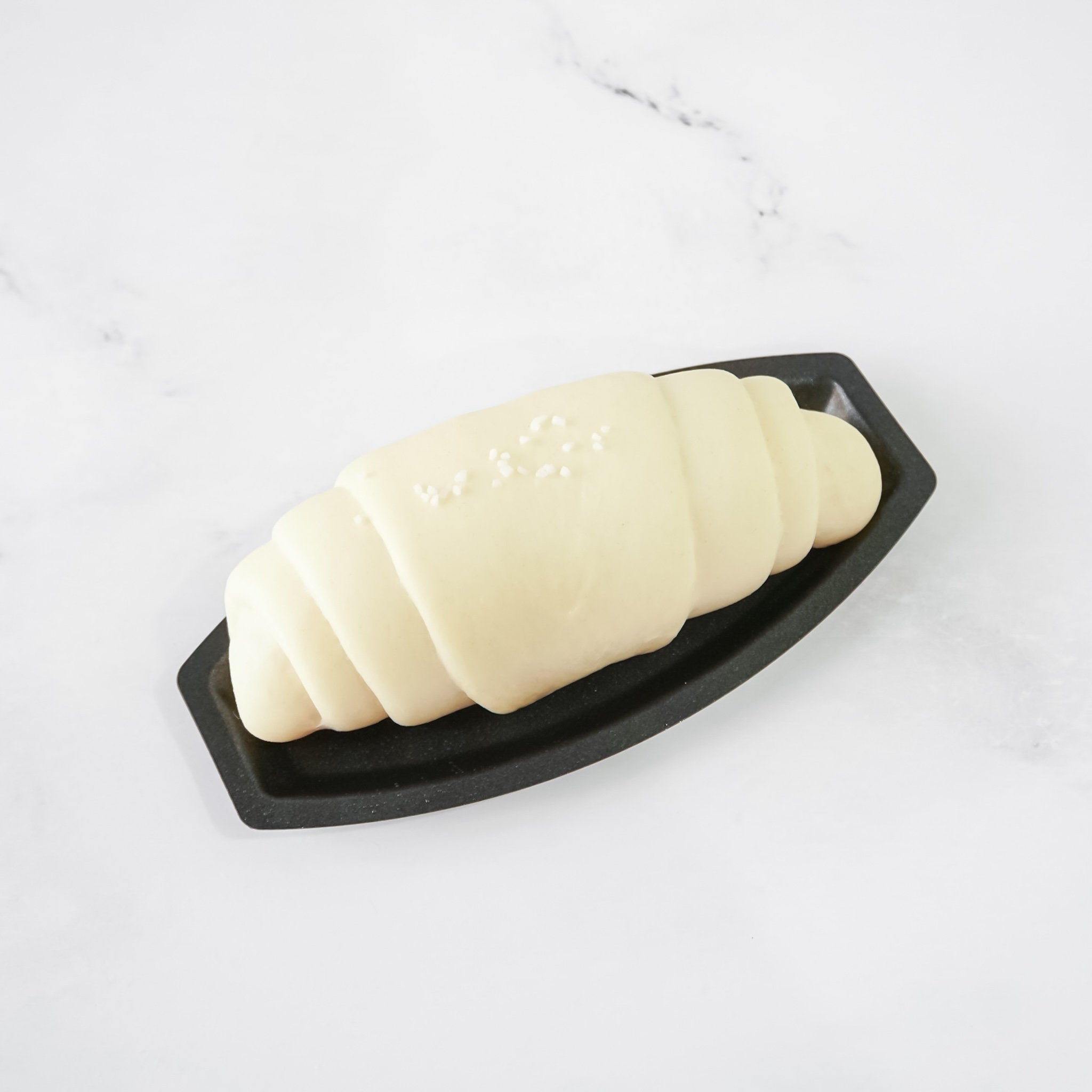Salt bread mold with a salted butter roll on a white background