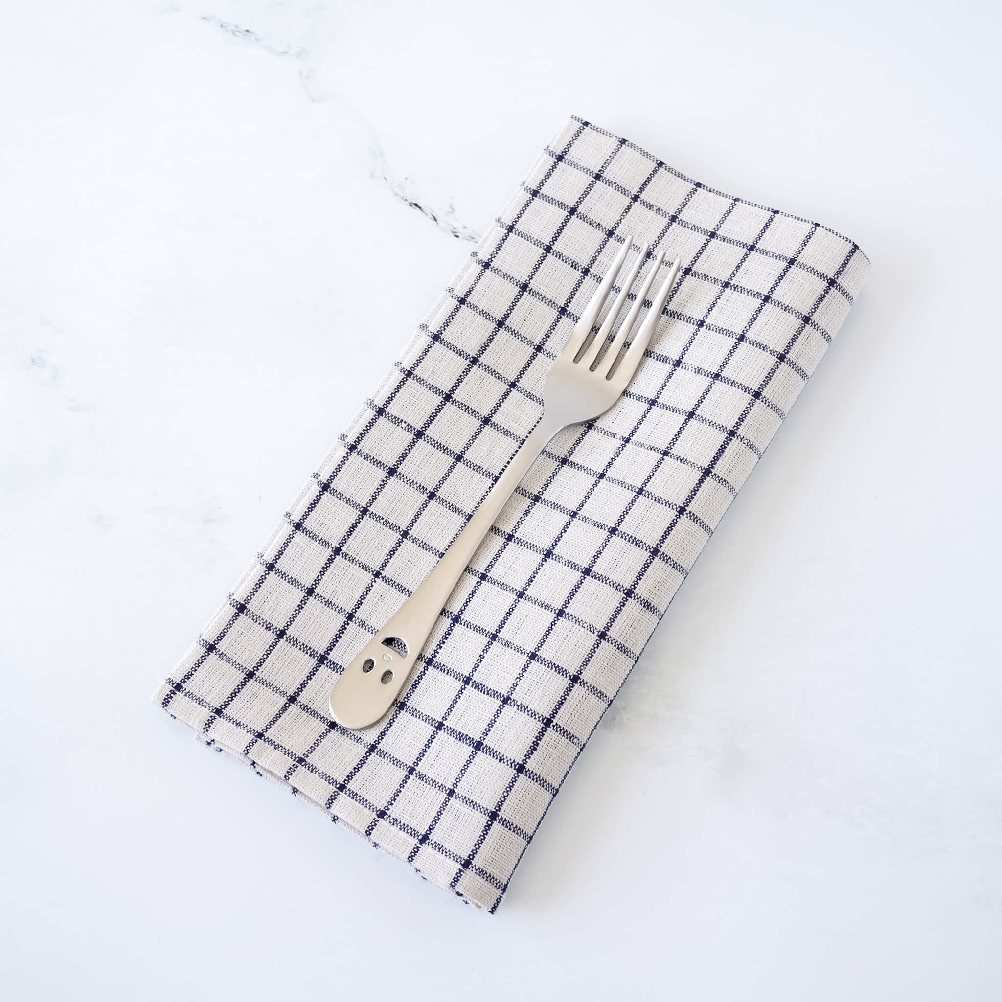 Checkered napkin with a fork on a white background