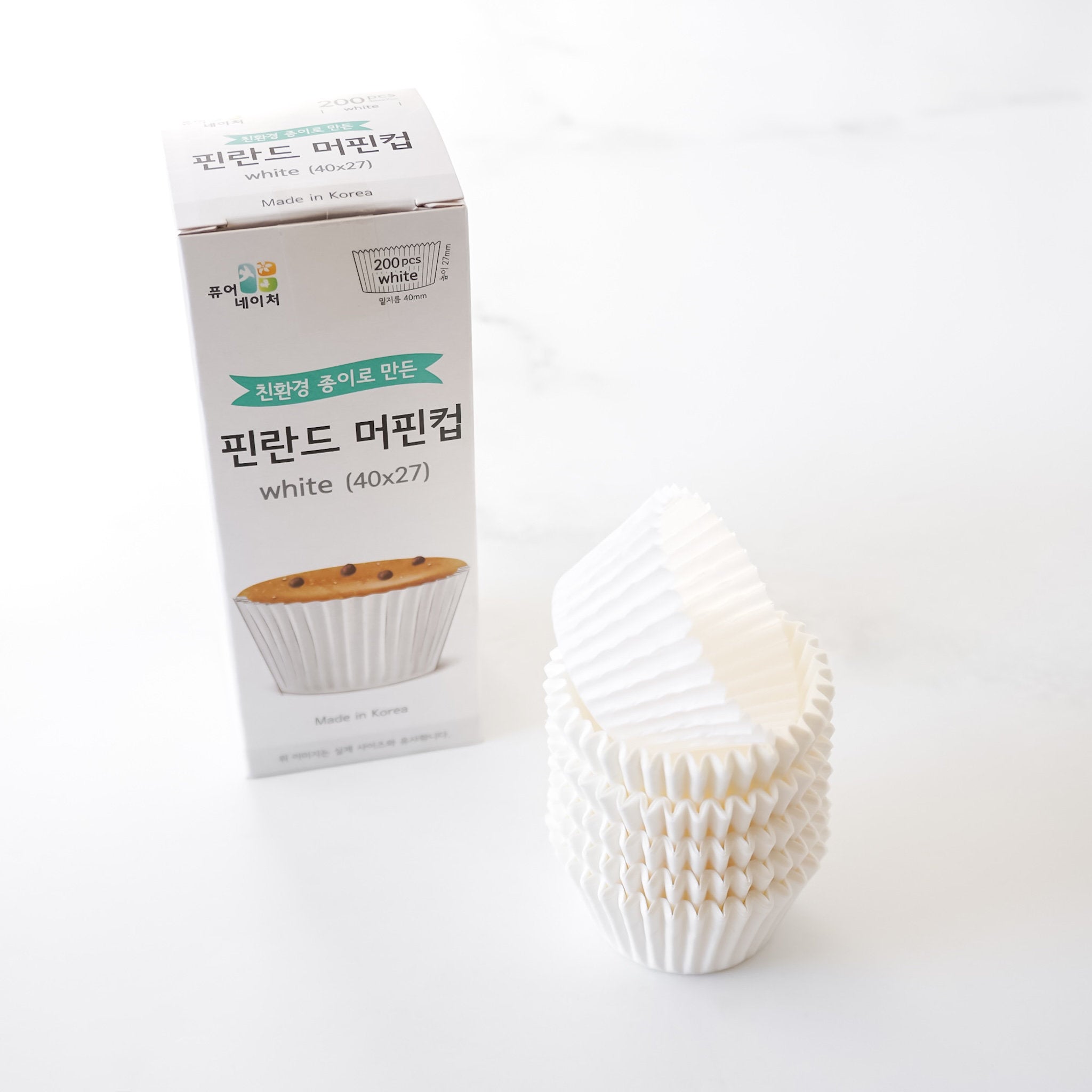 White muffin cups with a box on a white background