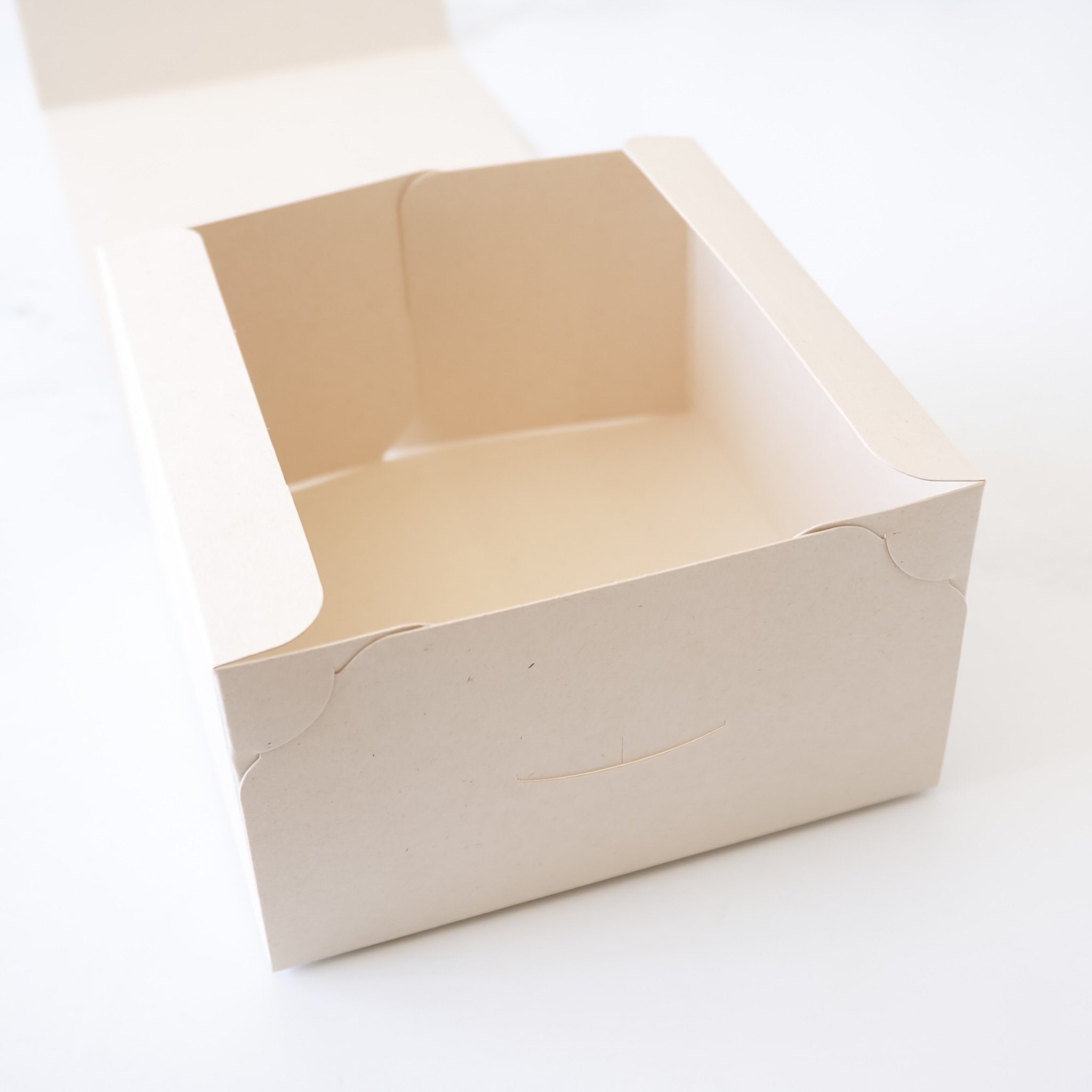 Open beige bakery box on a white background