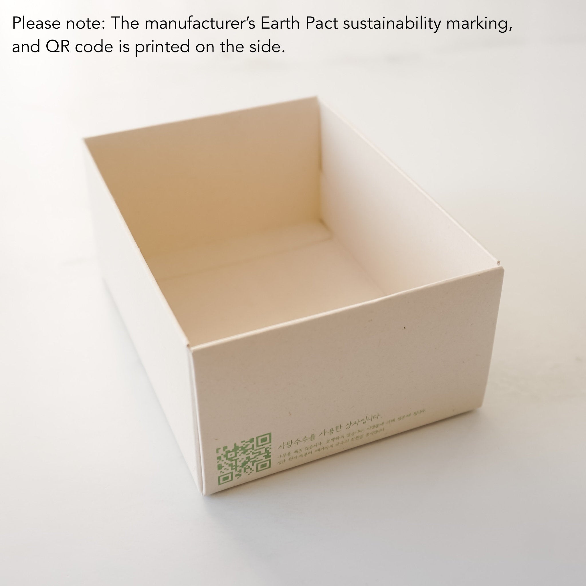 Beige box with sustainability marking and QR code on a white background
