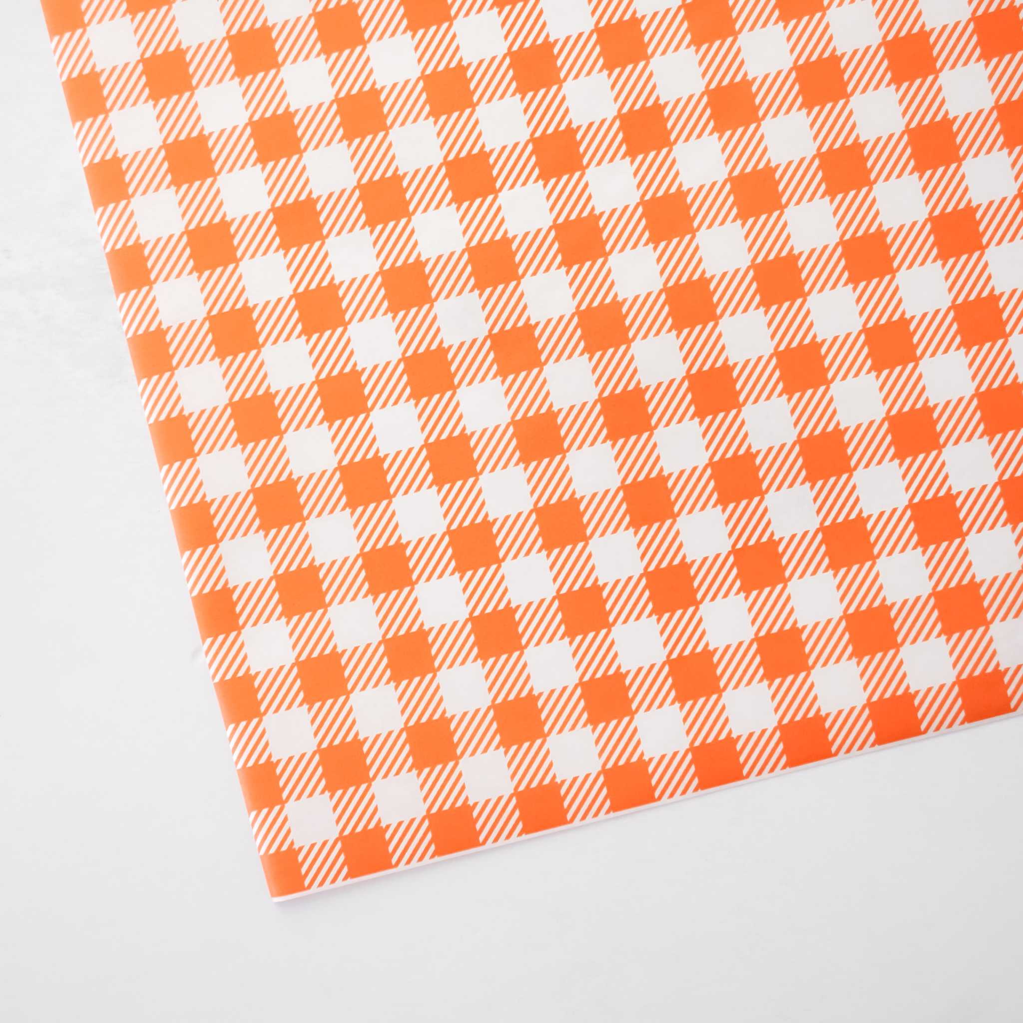 Orange and white checkered paper on a light gray background