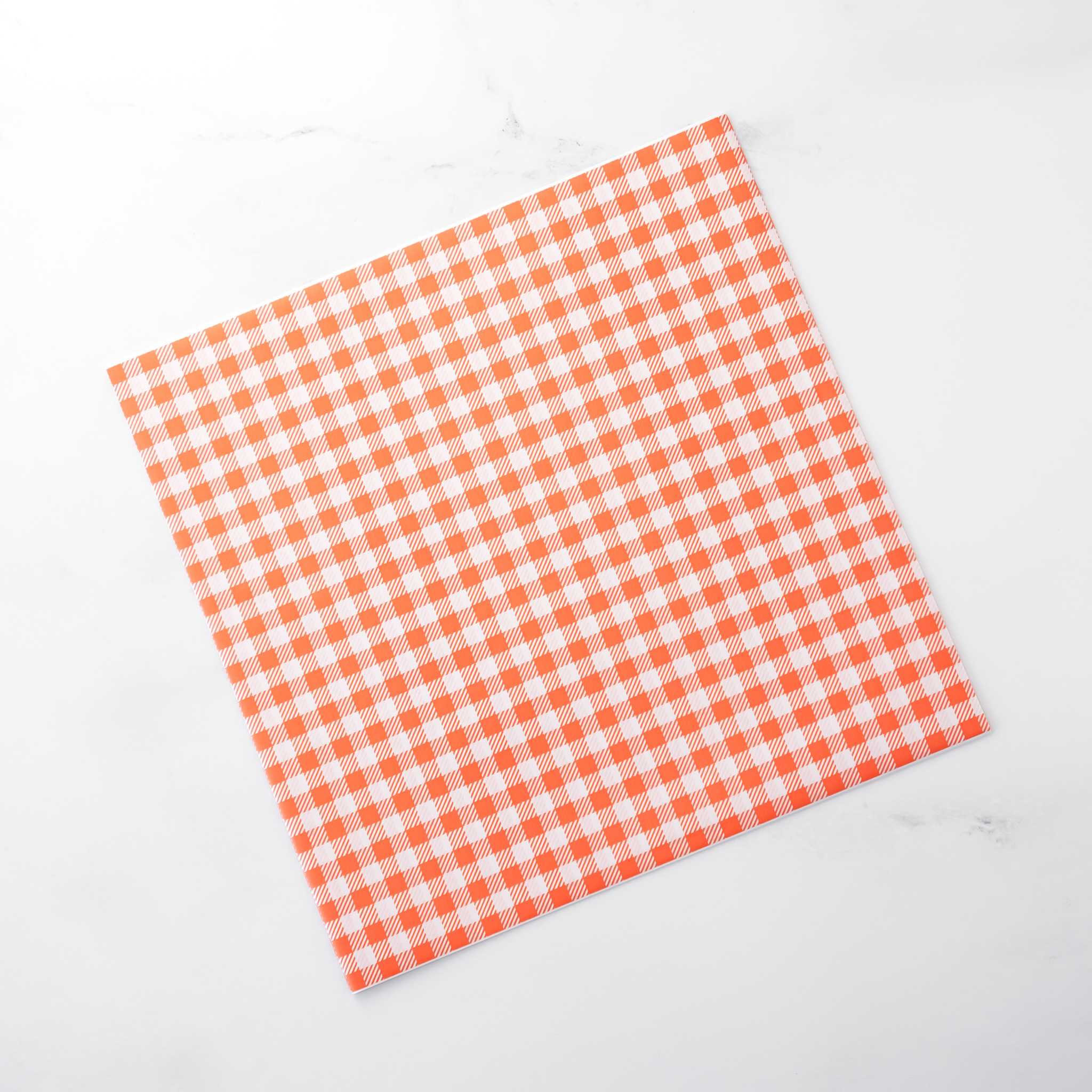 Orange and white checkered deli paper on a white background