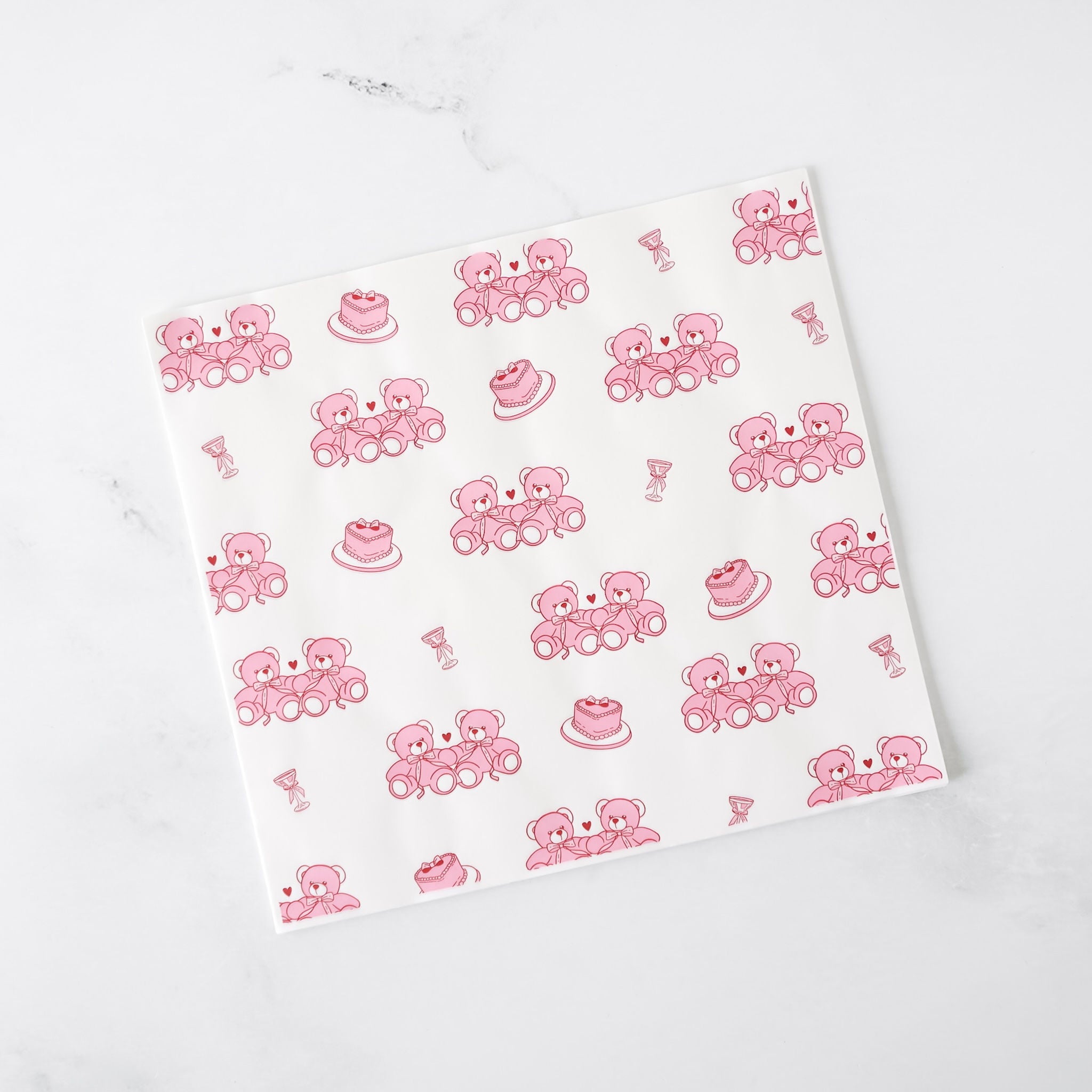 White paper with pink teddy bear and cake pattern on a white background