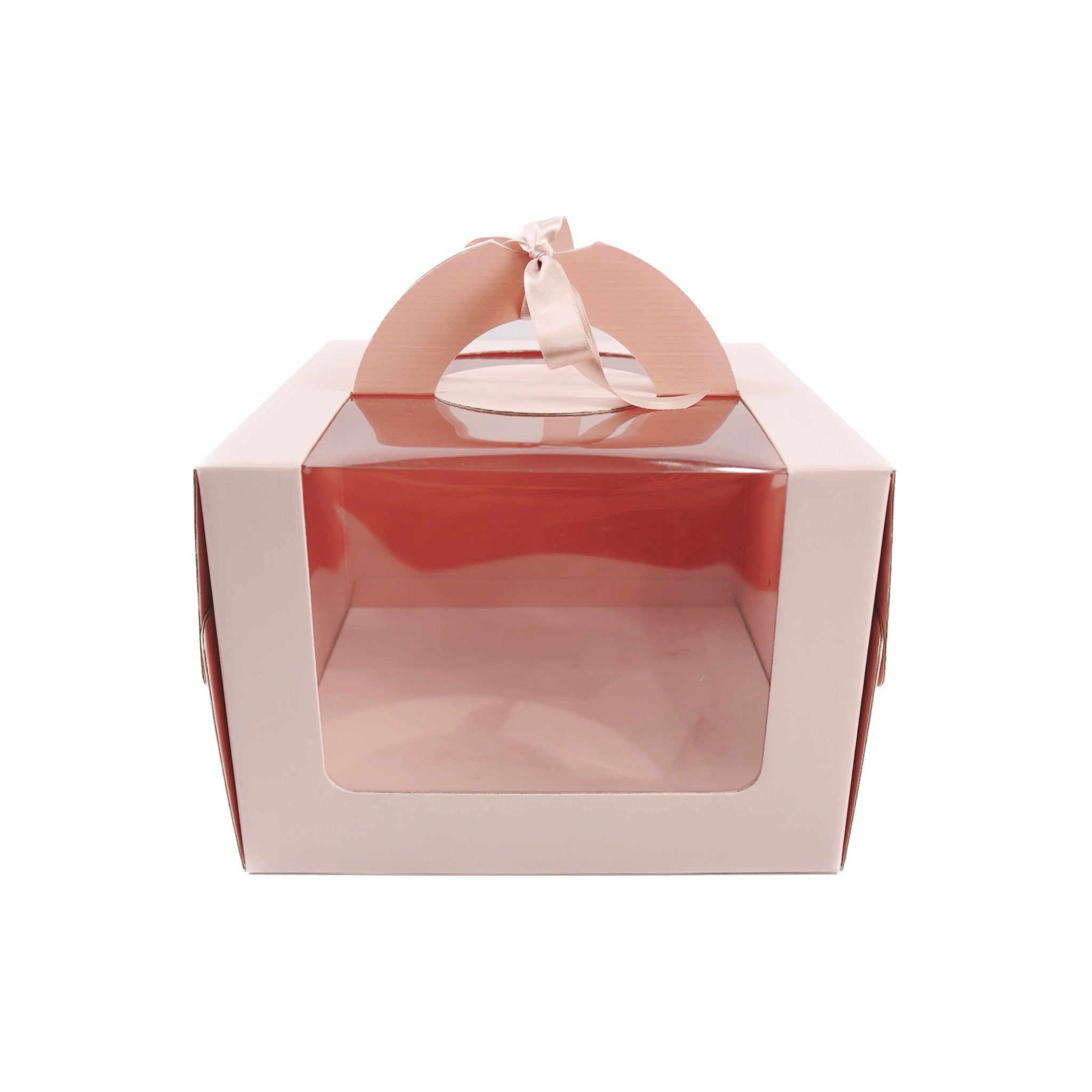 A blush pink cake box with a window, assembled and flat-packed, with a handle on top.