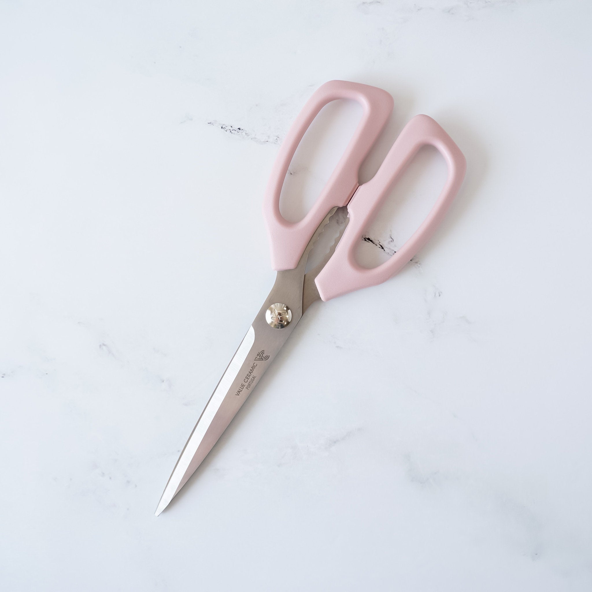 Pink kitchen shears with stainless steel blades.