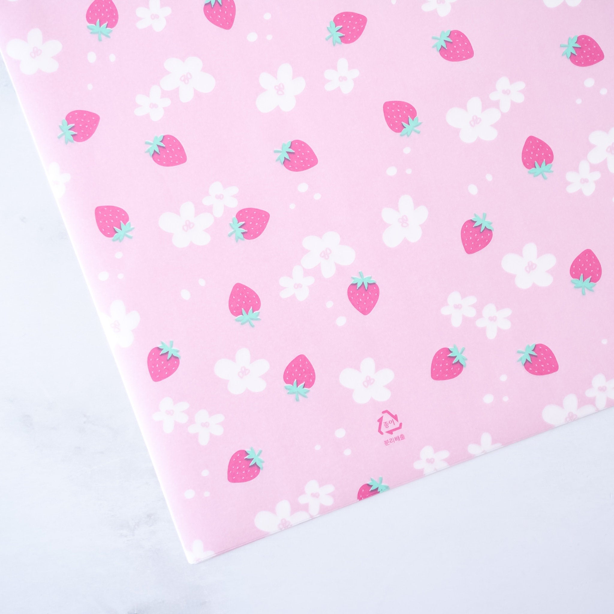 A pre-cut sheet of pink deli paper with a pattern of strawberries and white flowers.