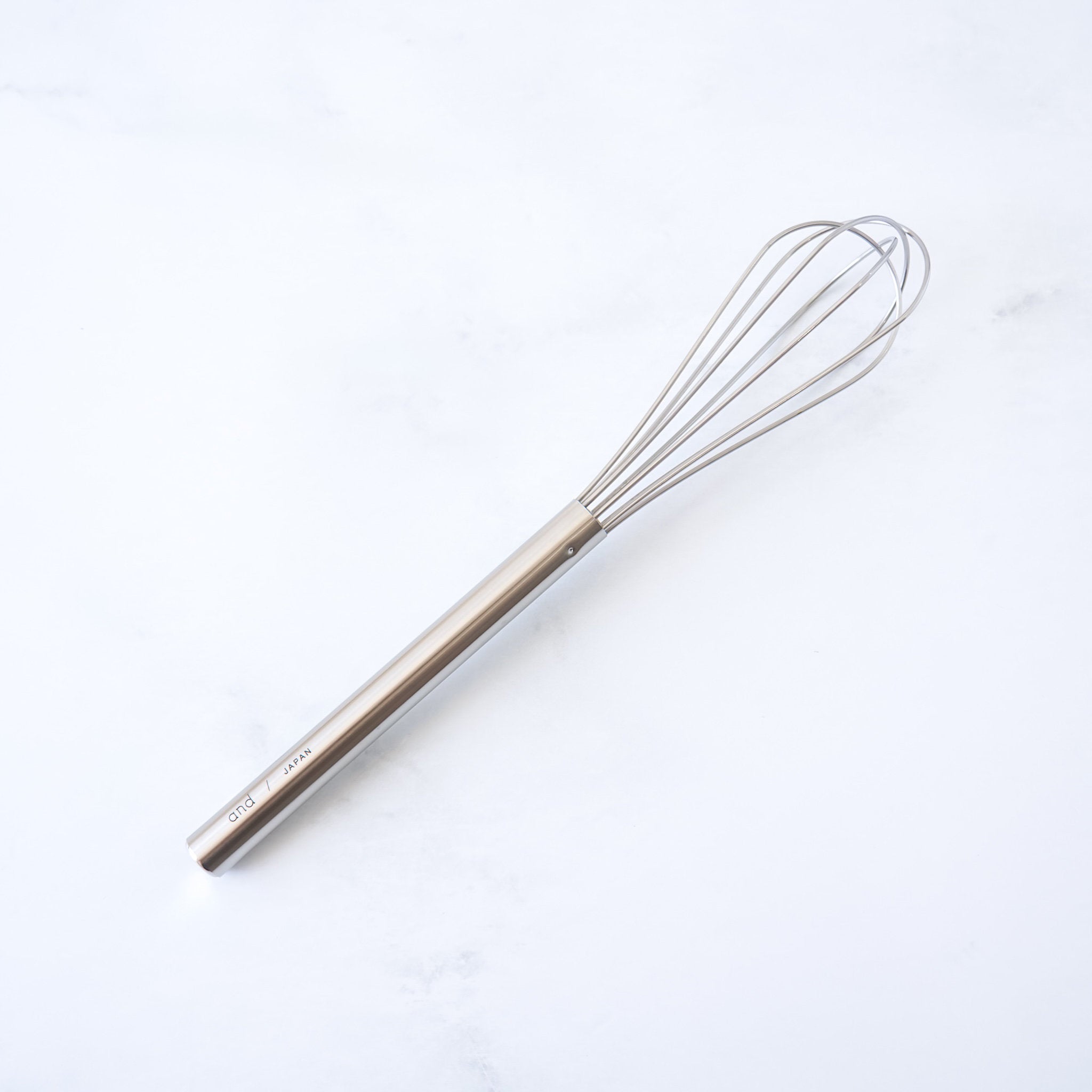 stainless steel mini whisk on a white background
