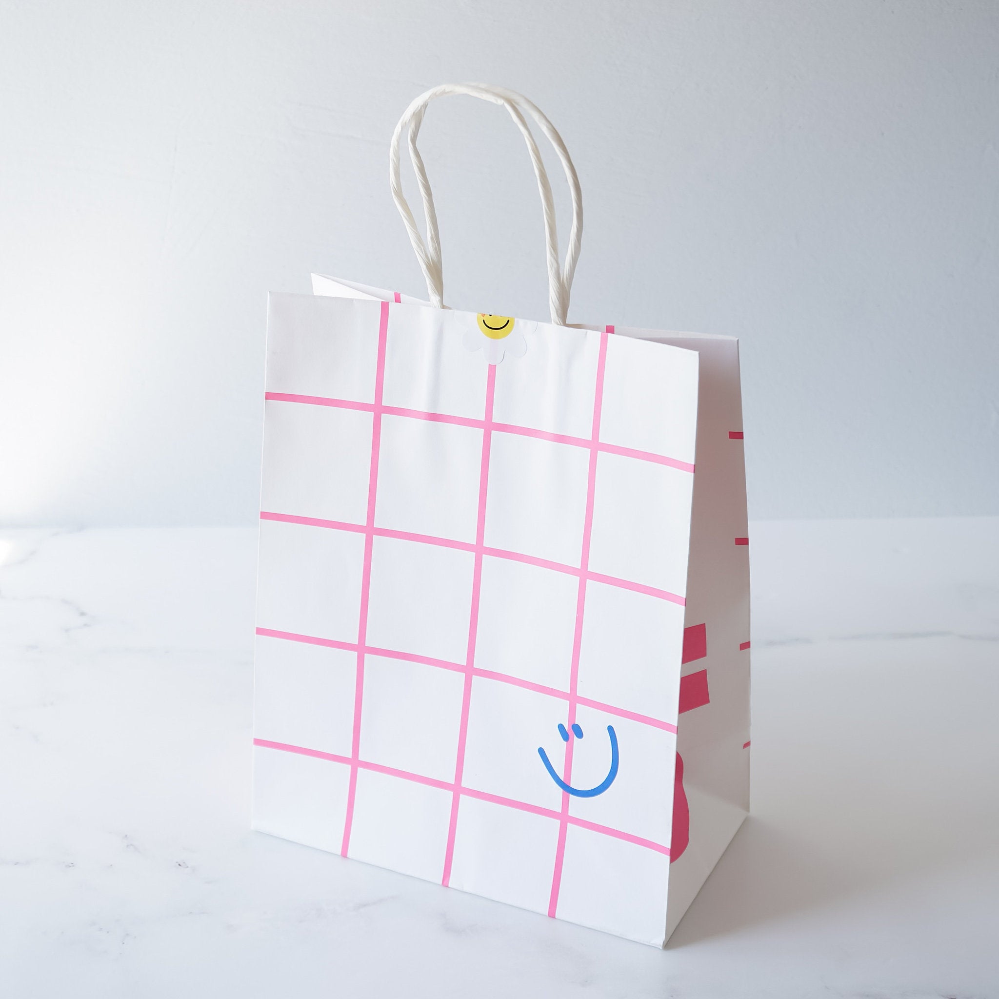 smiley face paper bag in pink