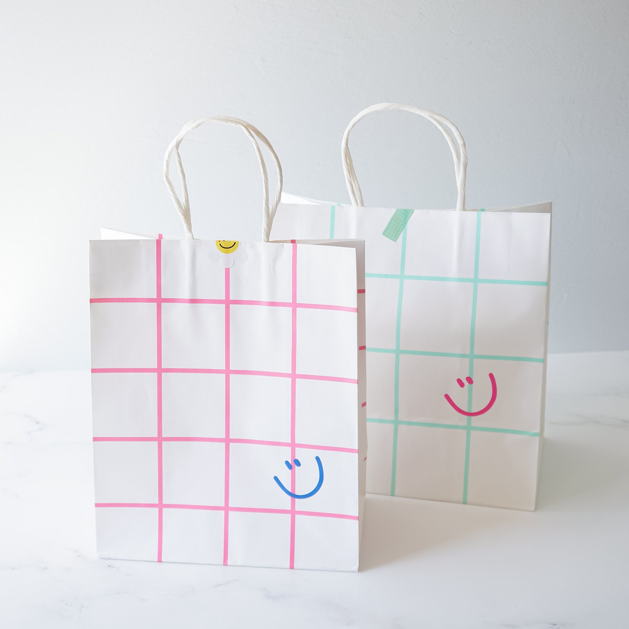smiley face shopping bags in pink and mint