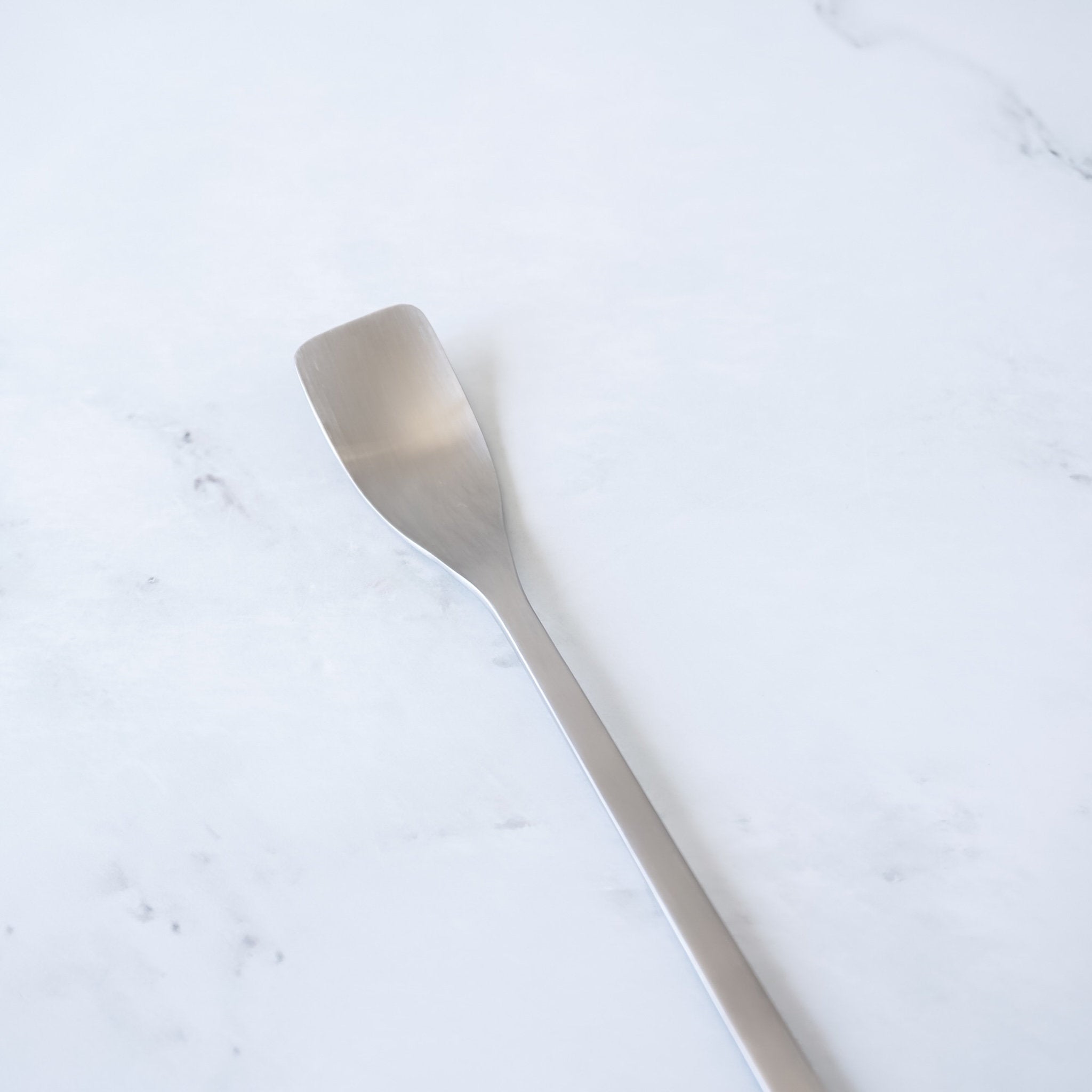Silver spoon on a light marble surface