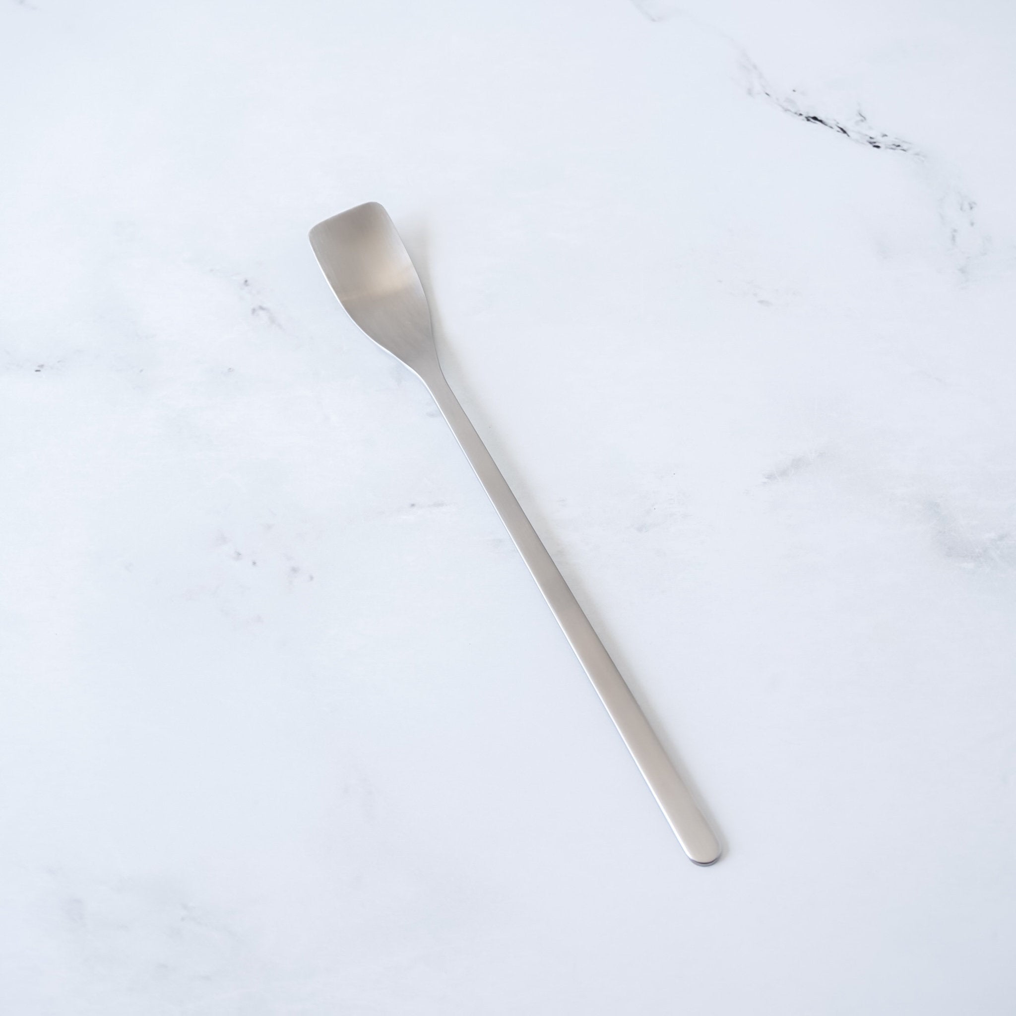 Silver spoon on a white marble surface