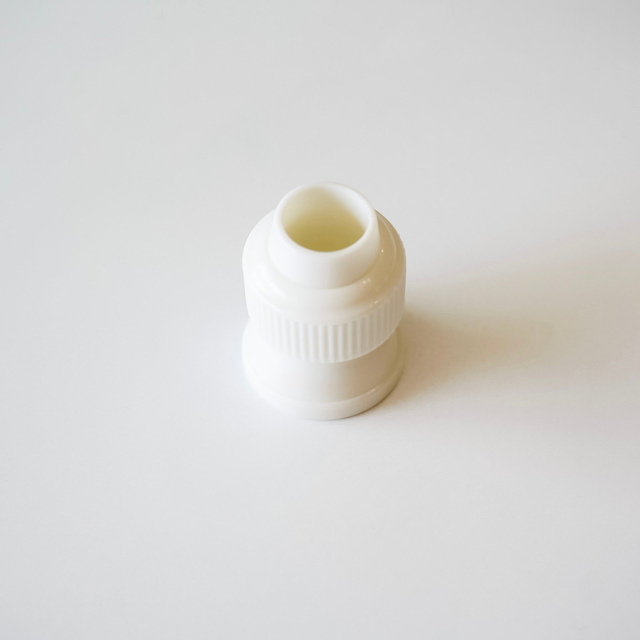 White plastic coupler on a light gray background