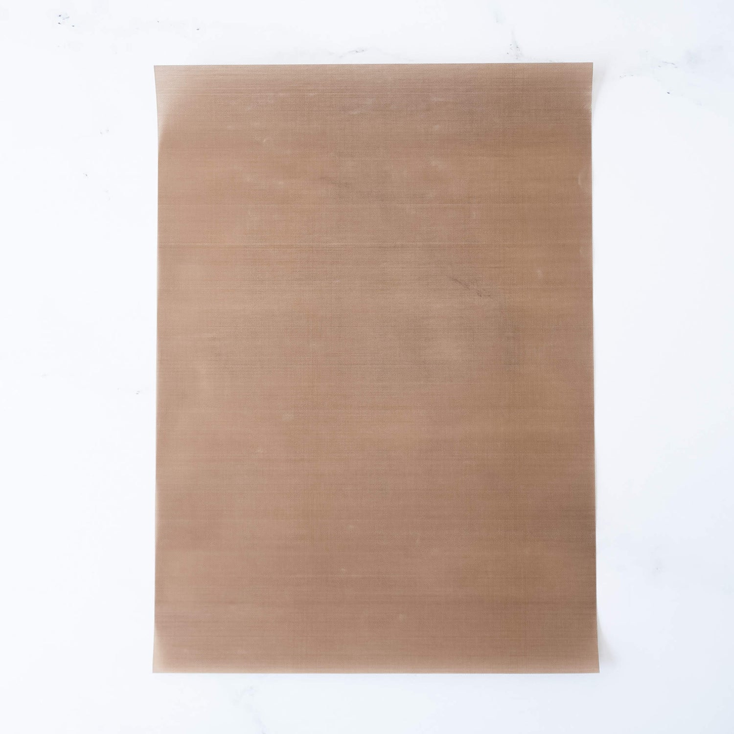A Teflon sheet with a non-stick surface, beige in color, placed on a white background.