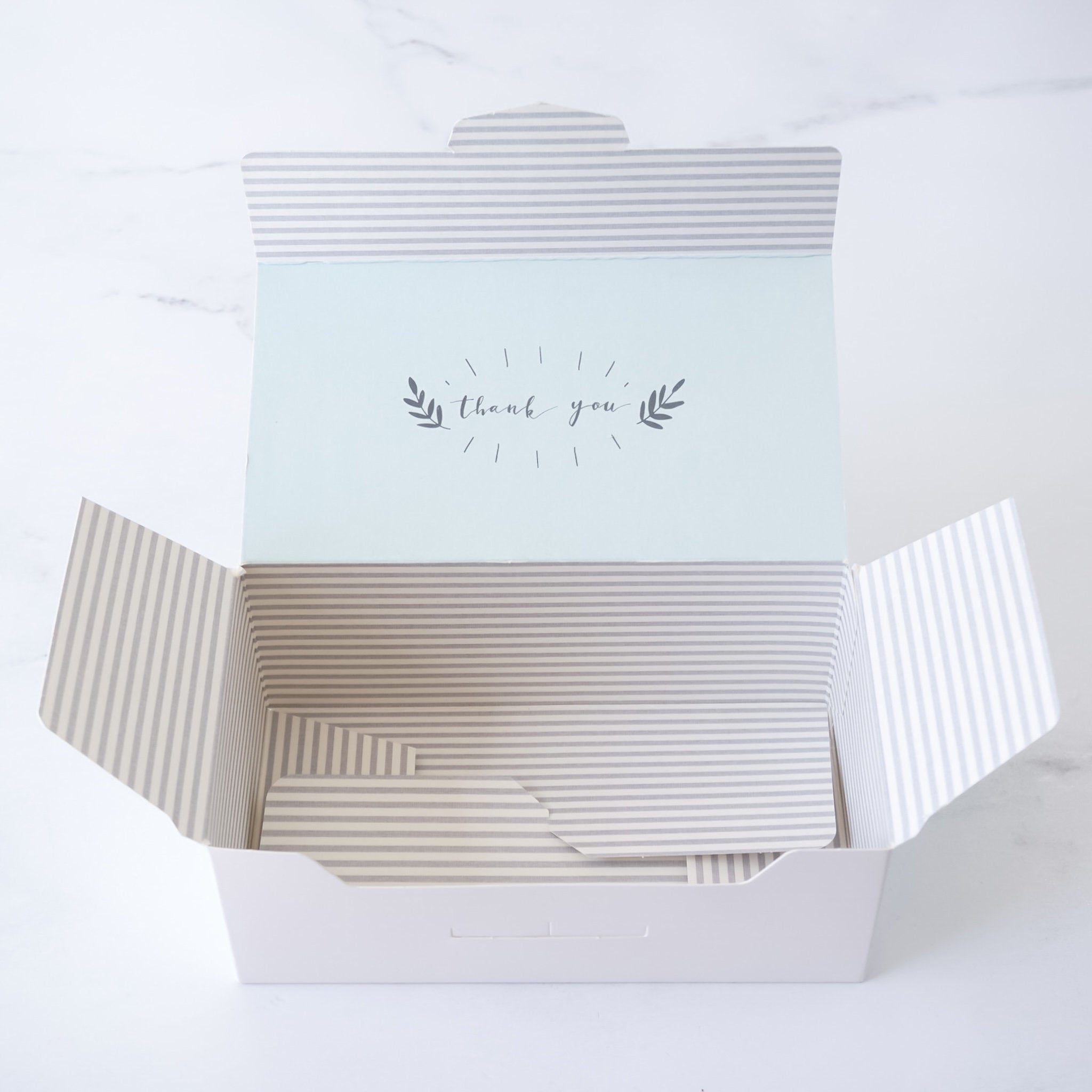 Open gift box with a light blue top inside that says &