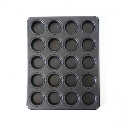 Black cupcake pan with multiple compartments on a white background
