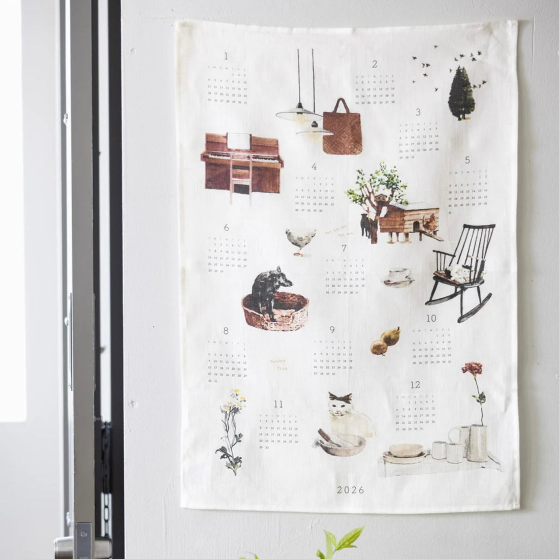 Calendar cloth hanging on a wall with illustrations of daily life scenes.