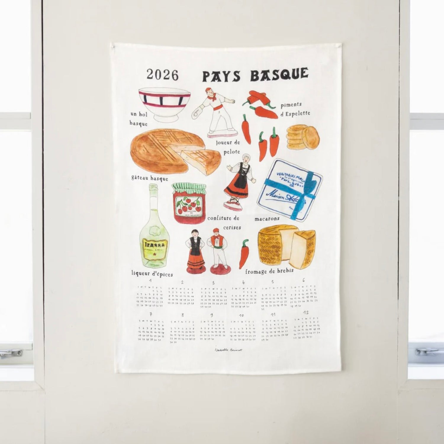 Calendar dishcloth with illustrations of food and culture on a white wall.
