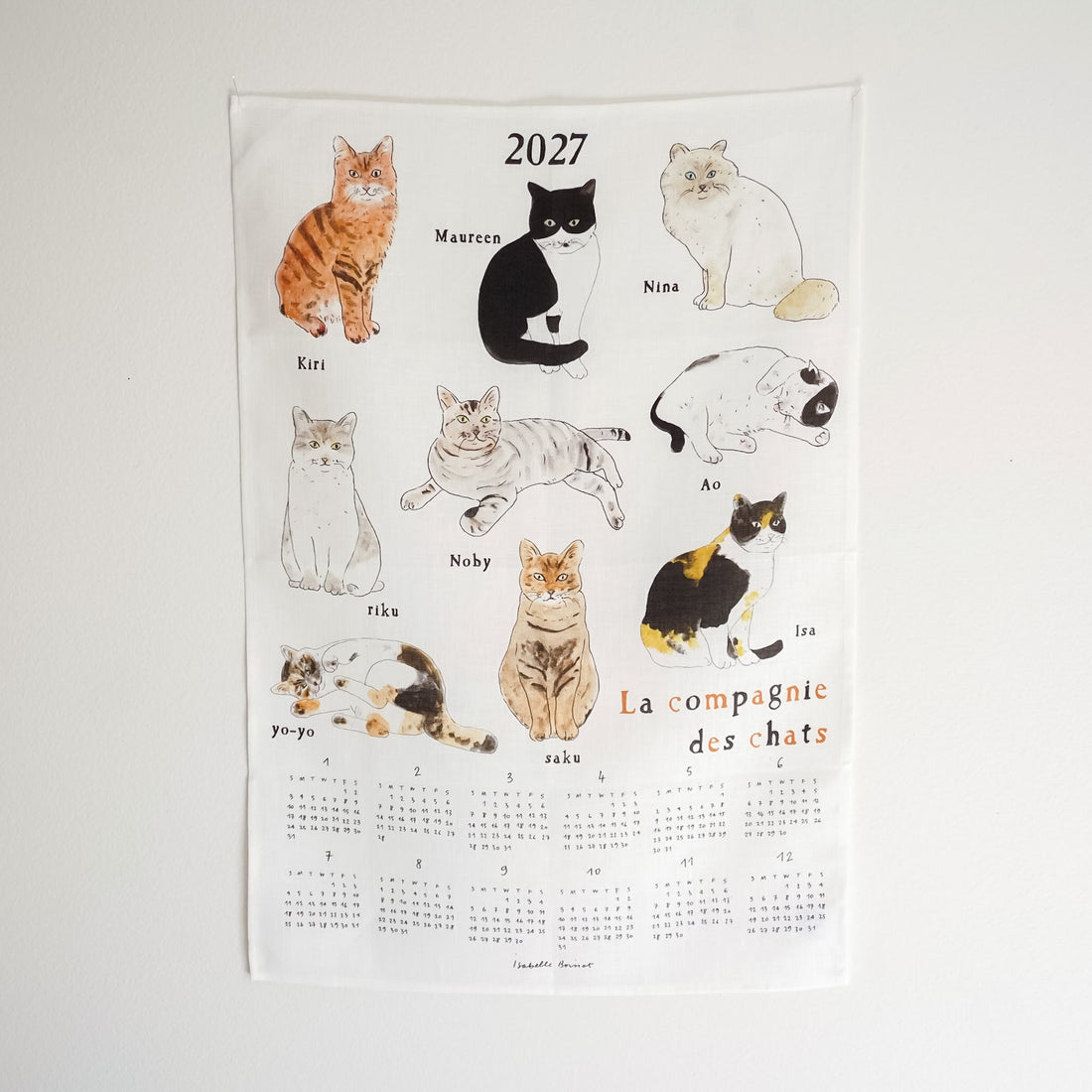 A 2027 French cat calendar poster featuring illustrated cats labeled with their names, including Kiri, Maureen, Nina, Ao, Nobby, Riku, Yo-Yo, Zaku, and Ira. The bottom half shows the printed calendar grids for each month, with the title &