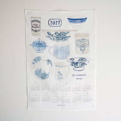 A blue-and-white ceramic tableware set illustrated on a white background, including a mug, bowl, plate, pitcher, lidded pot, and cup, with the text &
