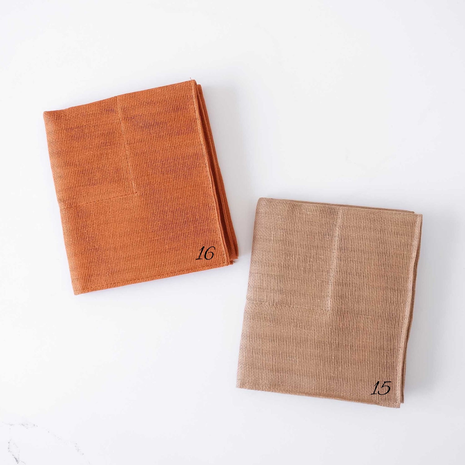 Two folded kitchen cloths with numbers on a white background