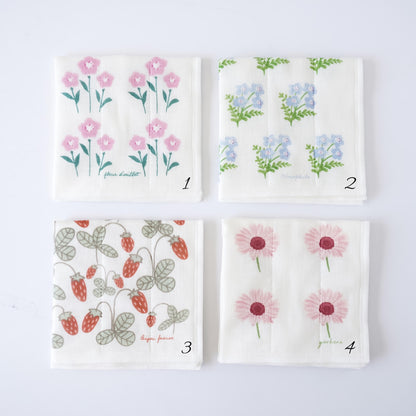 Four square white fabric dishcloths with different floral prints arranged in a 2x2 grid on a white background. Dishcloth 1 has pink flowers, dishcloth 2 has blue flowers, cloth 3 has red strawberries, and cloth 4 has pink daisies.