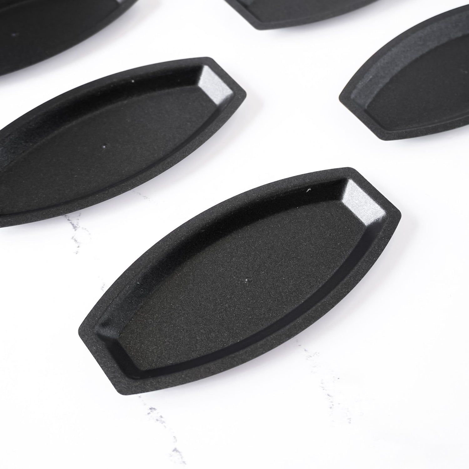 Black salted butter roll molds on a white background