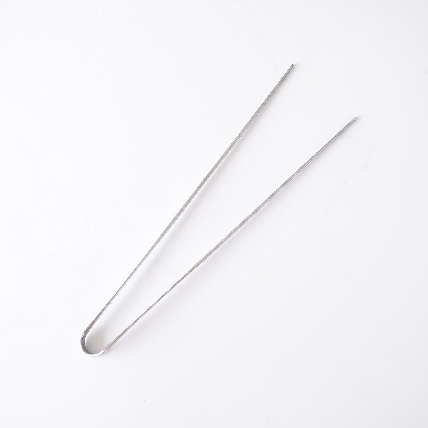 Stainless steel tongs on a white background