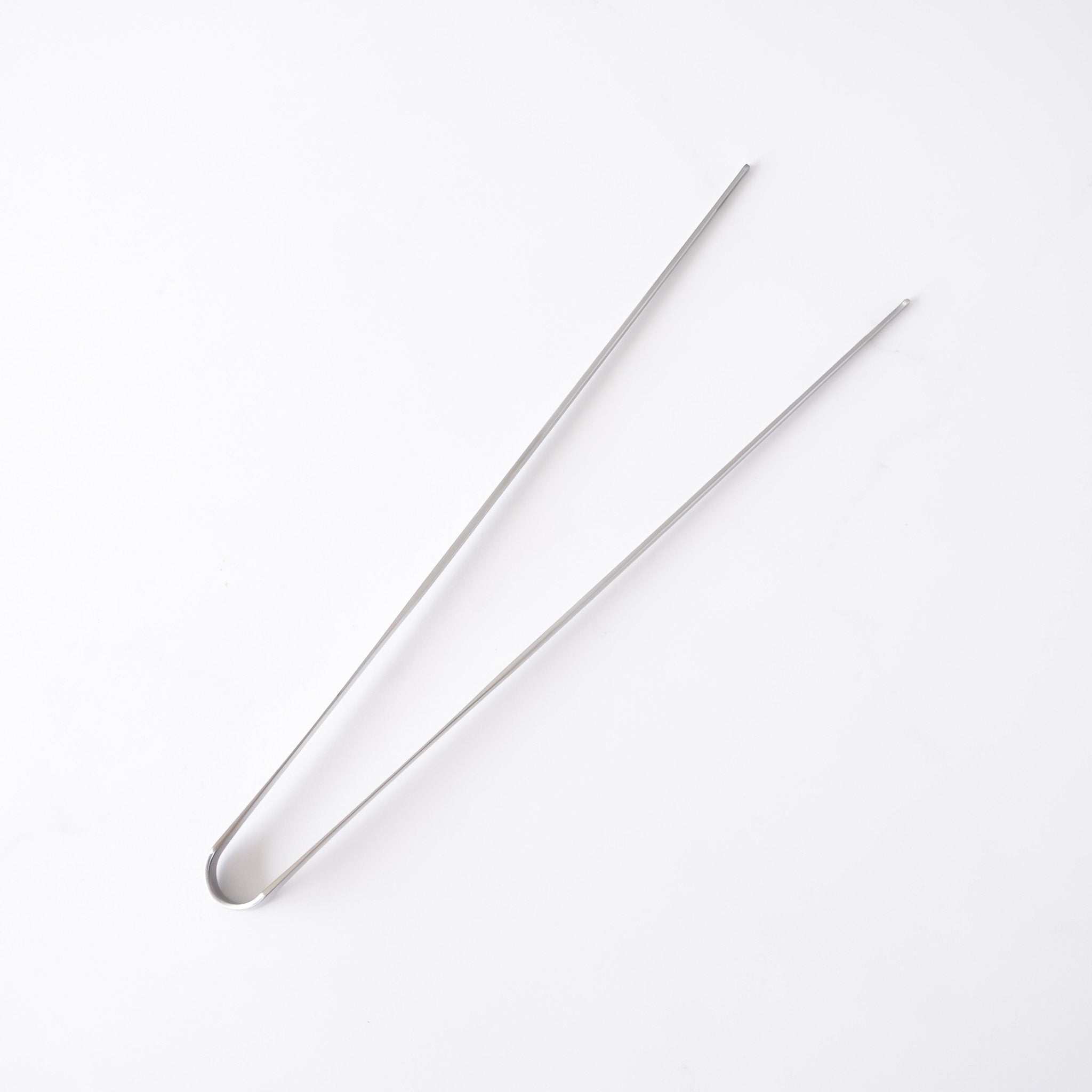Stainless steel tongs on a white background