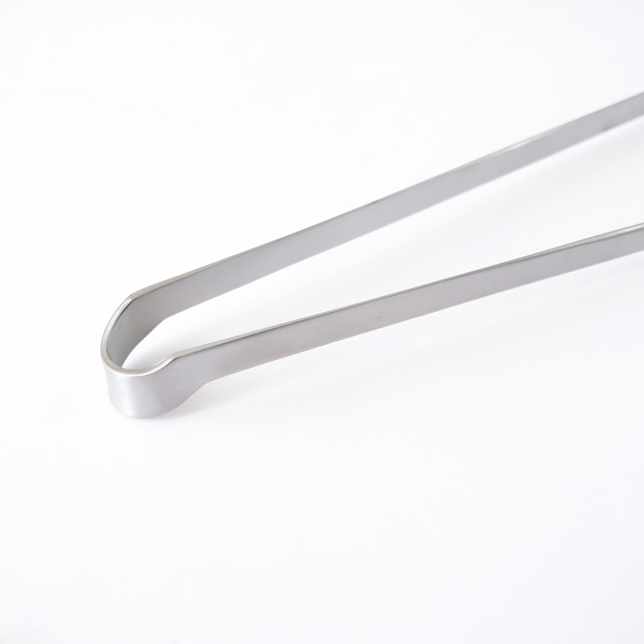 Metallic tongs on a white background