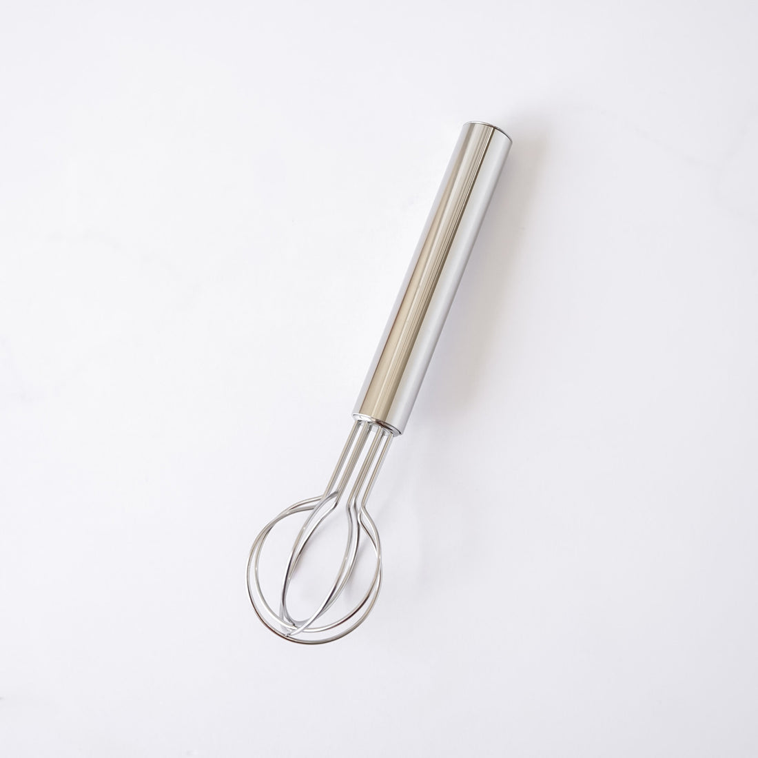 Metallic whisk on a white background