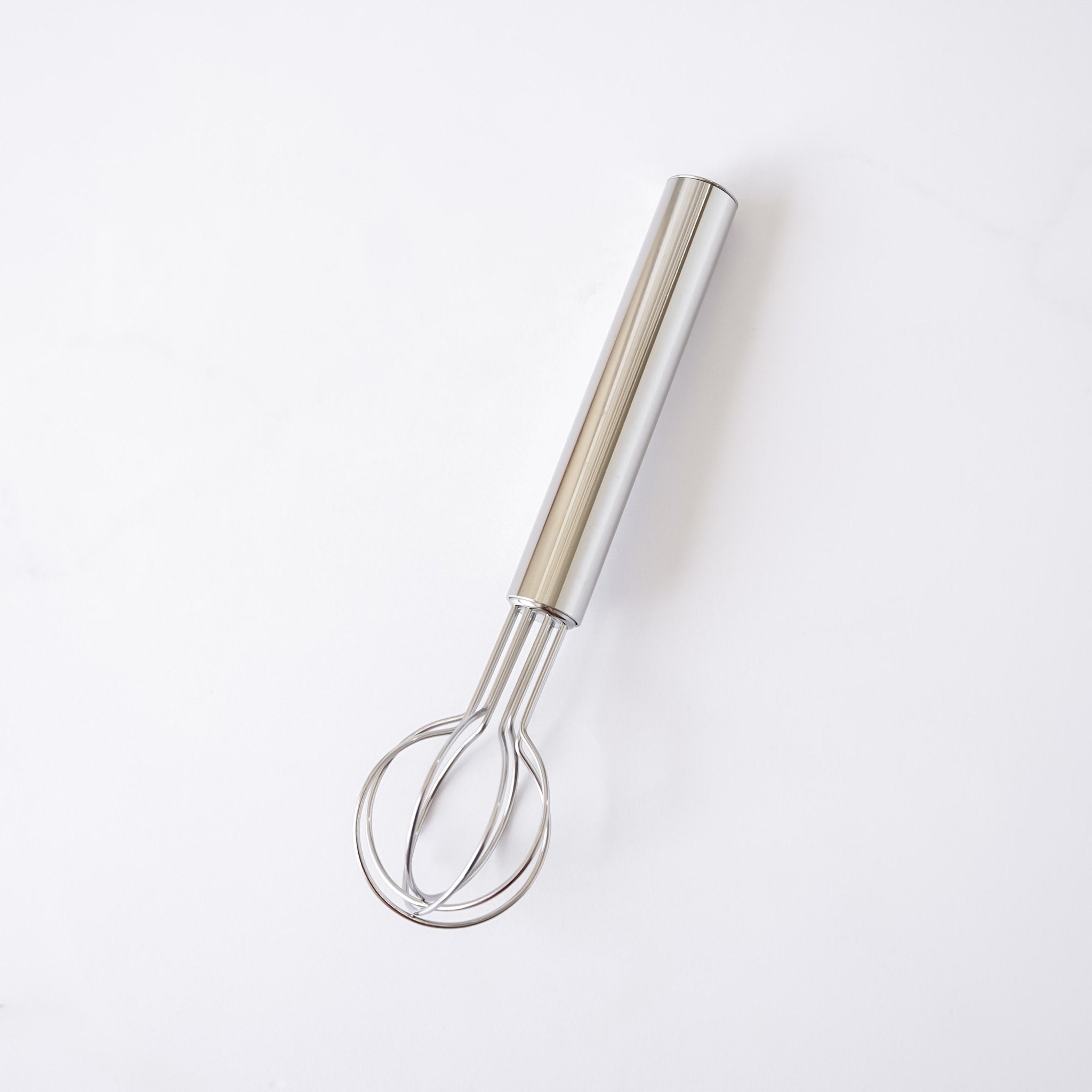 Metallic whisk on a white background